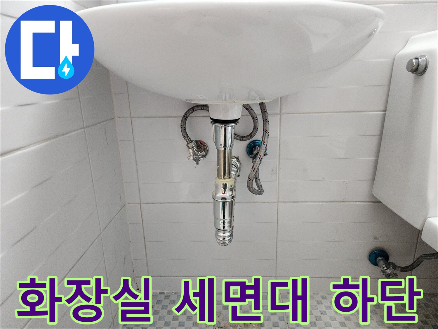 세면대 아래쪽의 벽면 타일과 노출된 수도 부속품