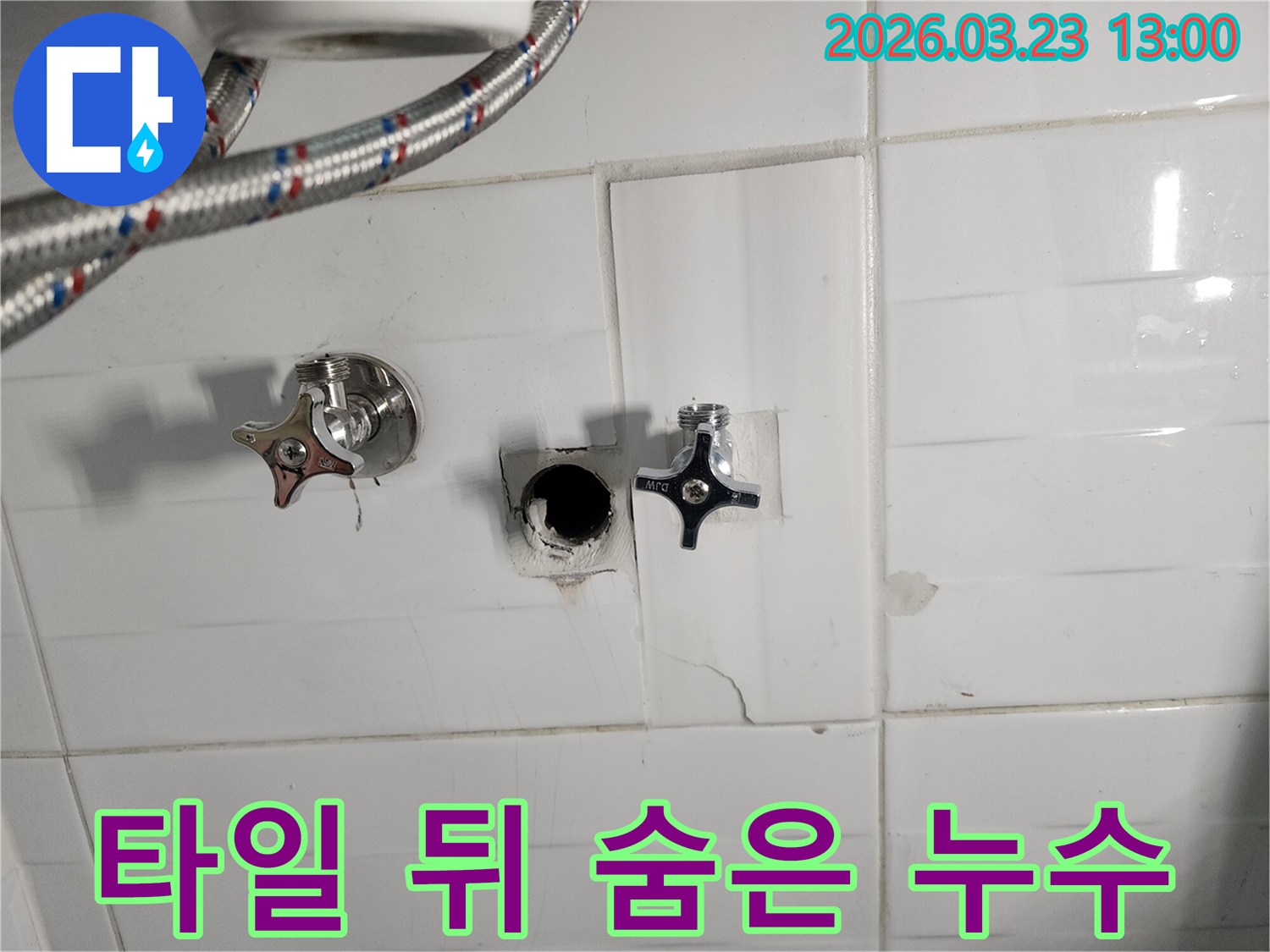 하얀색 타일 벽면 뒤에서-발생한 누수로 인해-타일이 손상되고-배관이 노출된-주택 누수 현장입니다.