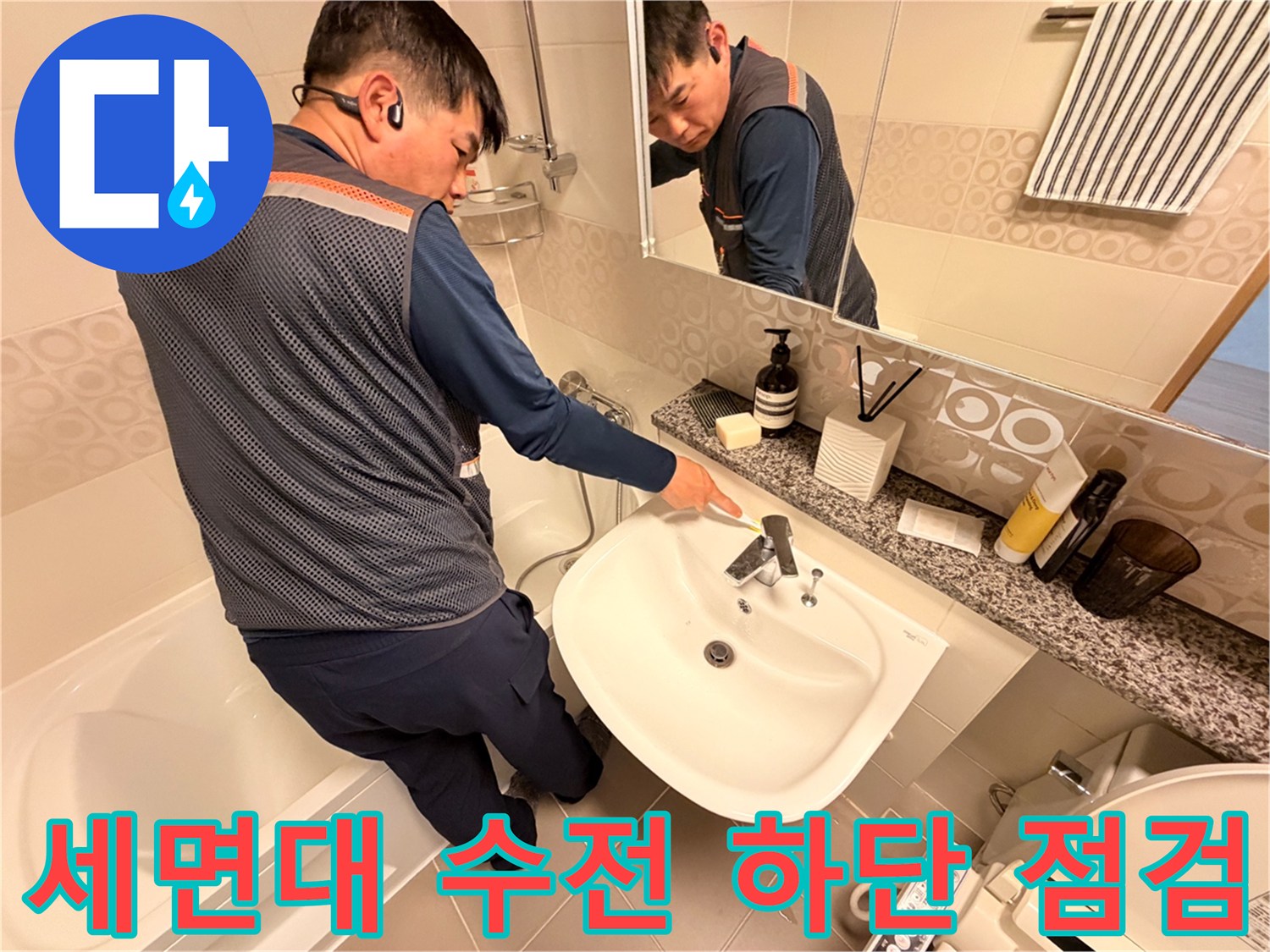 세면대 아래쪽 배관 연결 부위를 면밀히 살피는 작업 현장