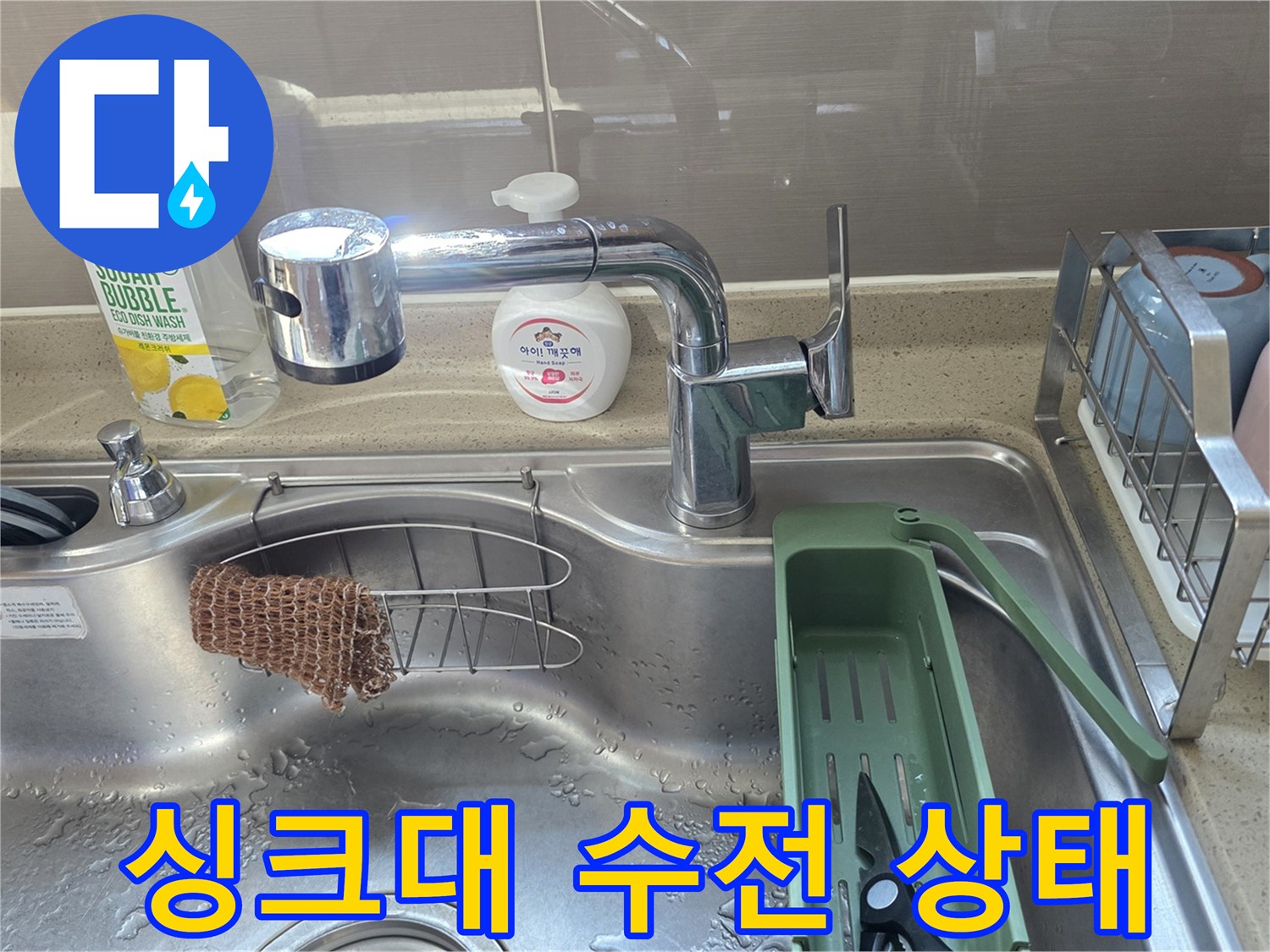 주방 싱크대 수전과 주변 세척 도구 모습