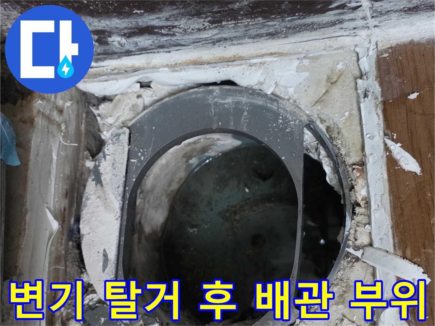 변기를 제거하고 드러난 오수관과 주변 젖은 바닥 모습