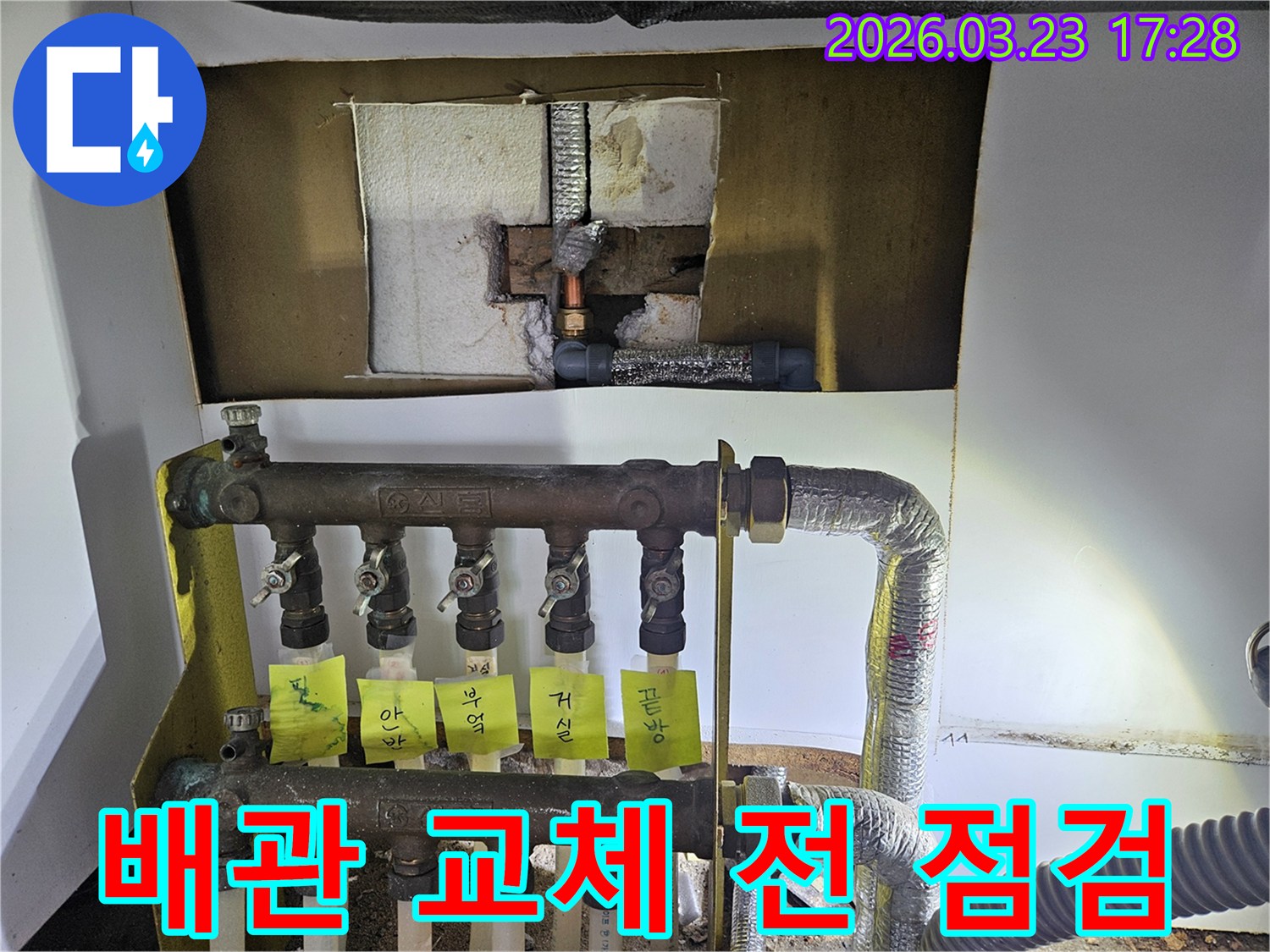 공세동 주택에서-난방 배관 교체-작업 전-누수 지점을-정확히 파악하기 위해-분배기 주변의-배관을 면밀히-검사하는-누수 전문 엔지니어의-작업 현장