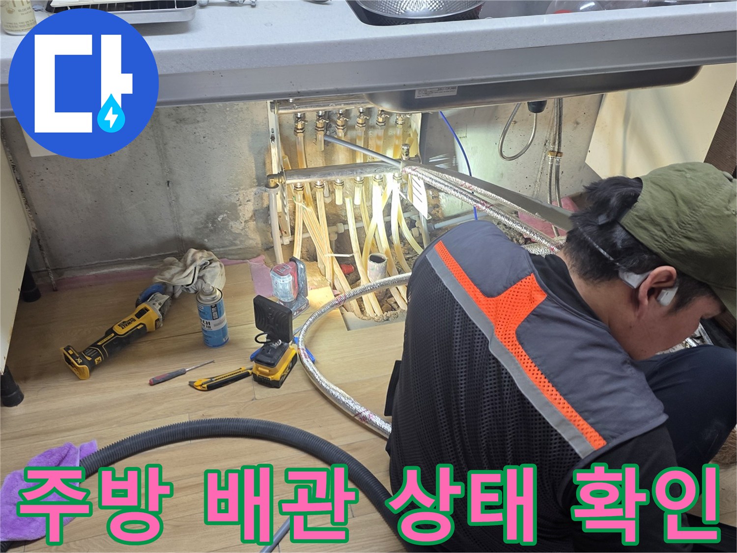 싱크대 하부장 내부 배관과 전문 장비를 사용하는 모습
