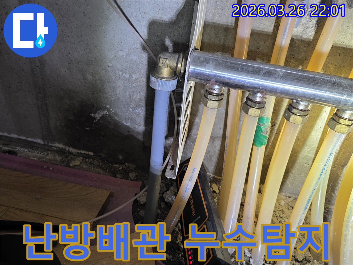 이 이미지는-온수 배관 누수-탐지 현장에서-젖은 벽면과-배관-그리고-탐지 장비를-보여줍니다.