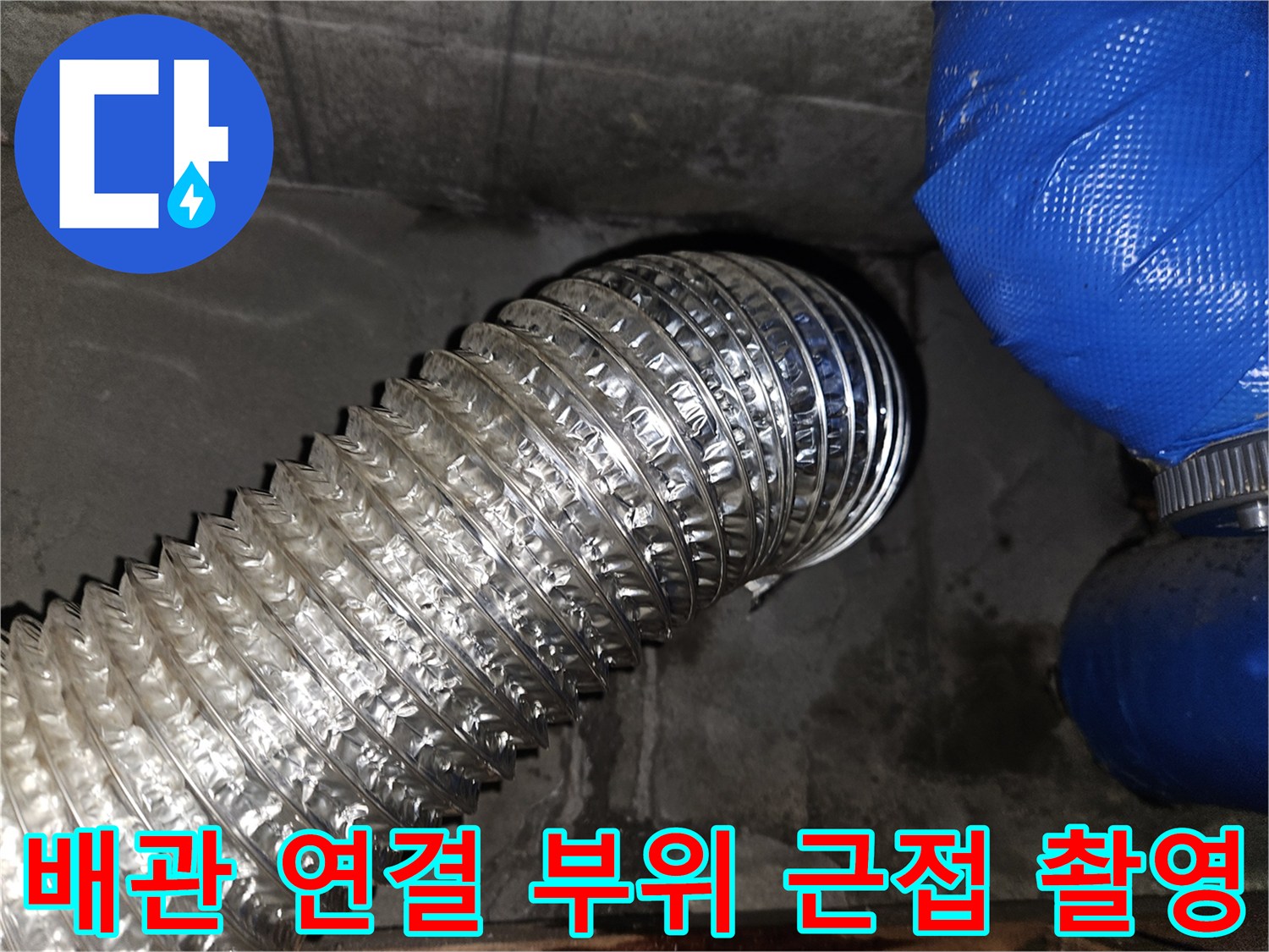 은색 주름 배관과 파란색 호스-누수 지점 확인 중