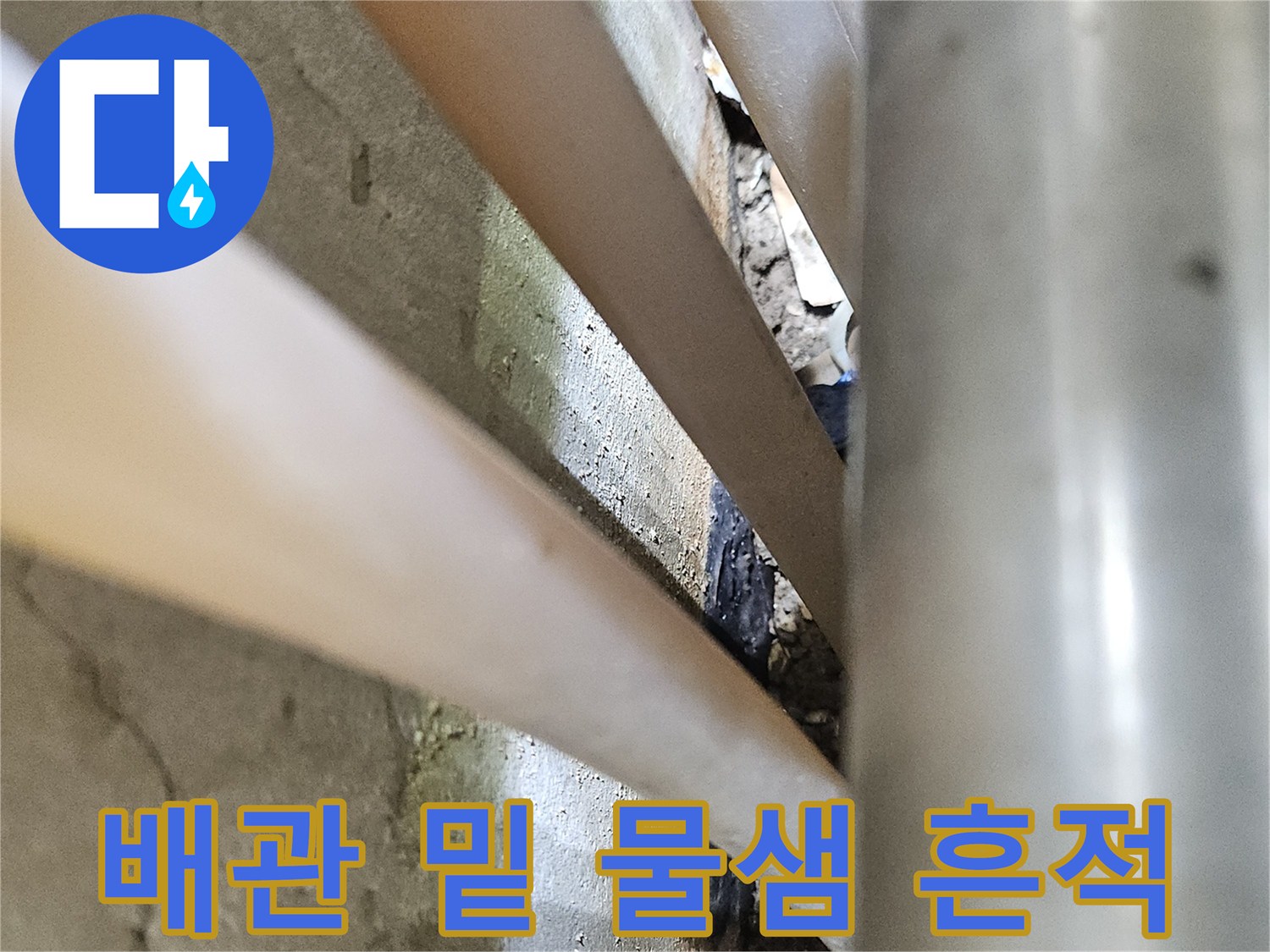 배관 아래쪽 콘크리트가 변색된 누수 현장 사진입니다.