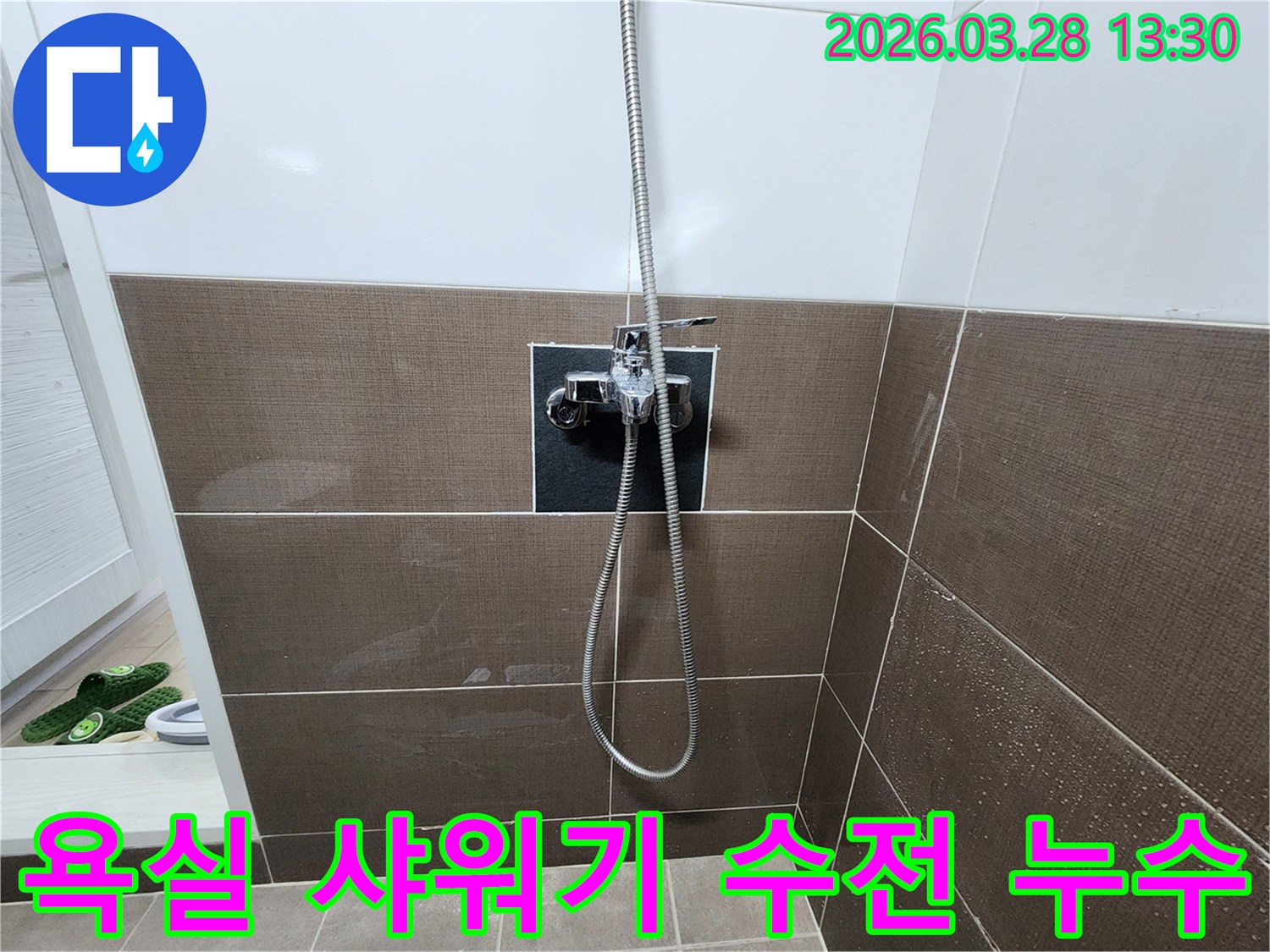 욕실 벽면의 샤워기 수전에서-누수가 발생하여-타일이 젖은 모습입니다