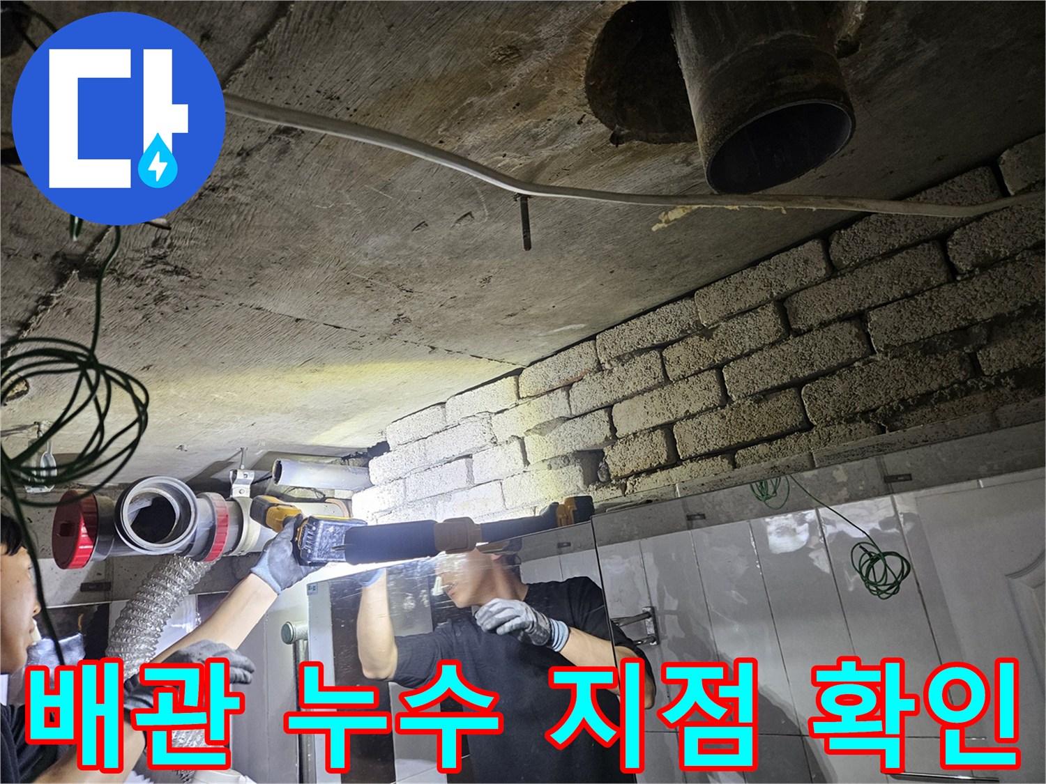 천장 배관의 파손 부위를 찾기 위해 조명을 사용하여 검사하는 장면