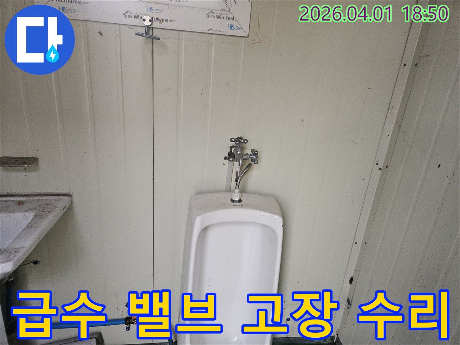 가설 화장실 소변기 하단에 연결된-파란색 급수 호스의 밸브가 고장 나-누수가 발생한 것을 수리하는 과정을 담은 사진