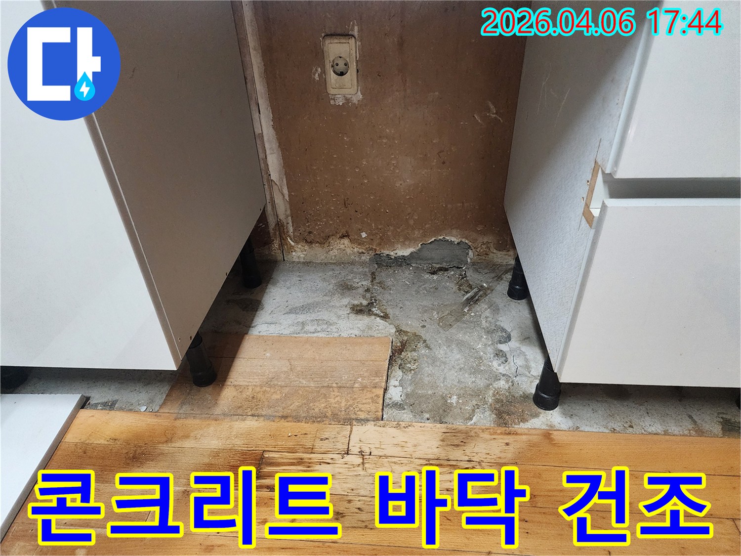 싱크대 아래 콘크리트 바닥이 젖어있고-주변 마루와 벽면이 손상된-심각한 누수 현장