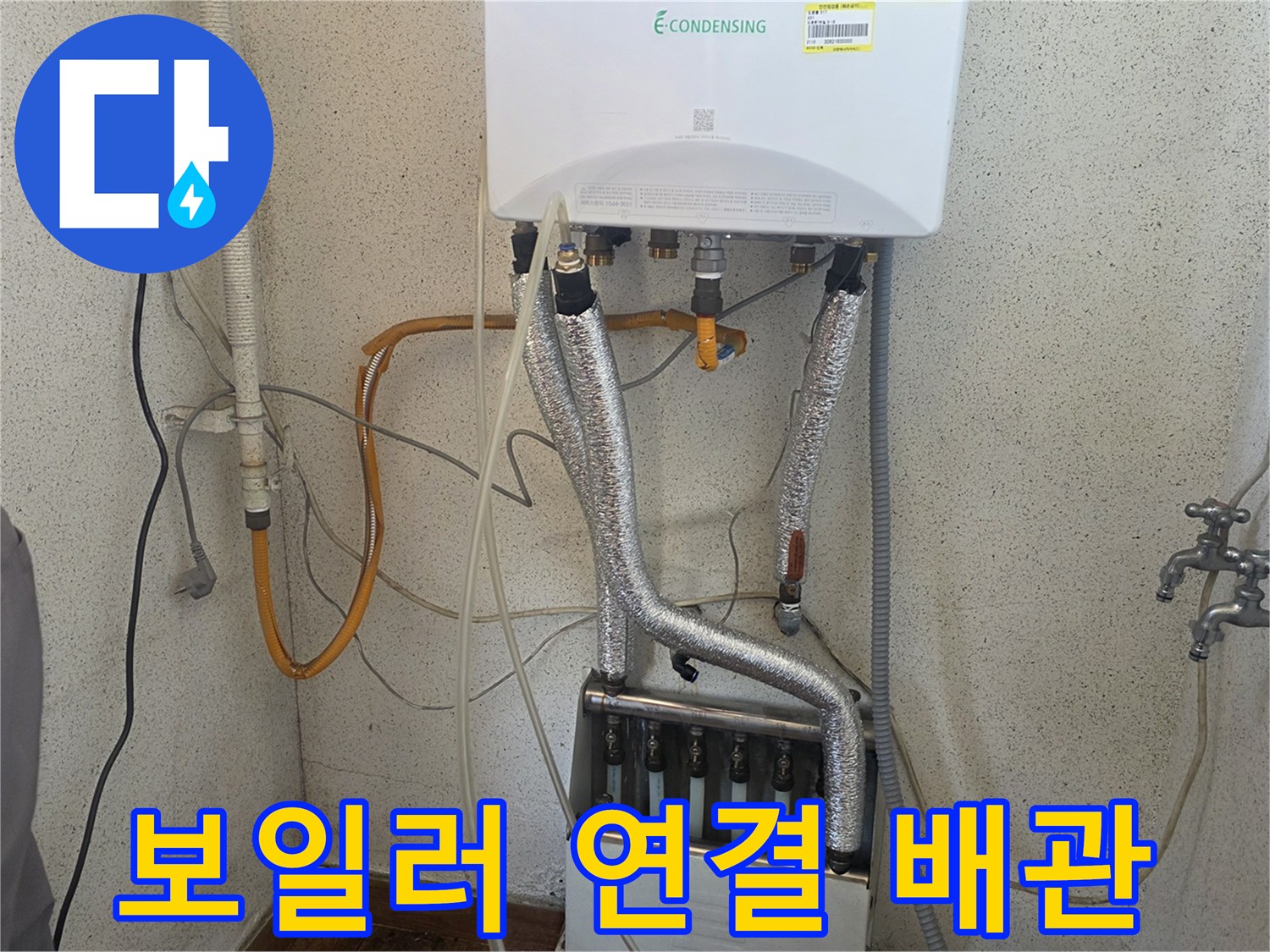 보일러 하단에 연결된 은색 보온재 배관 모습