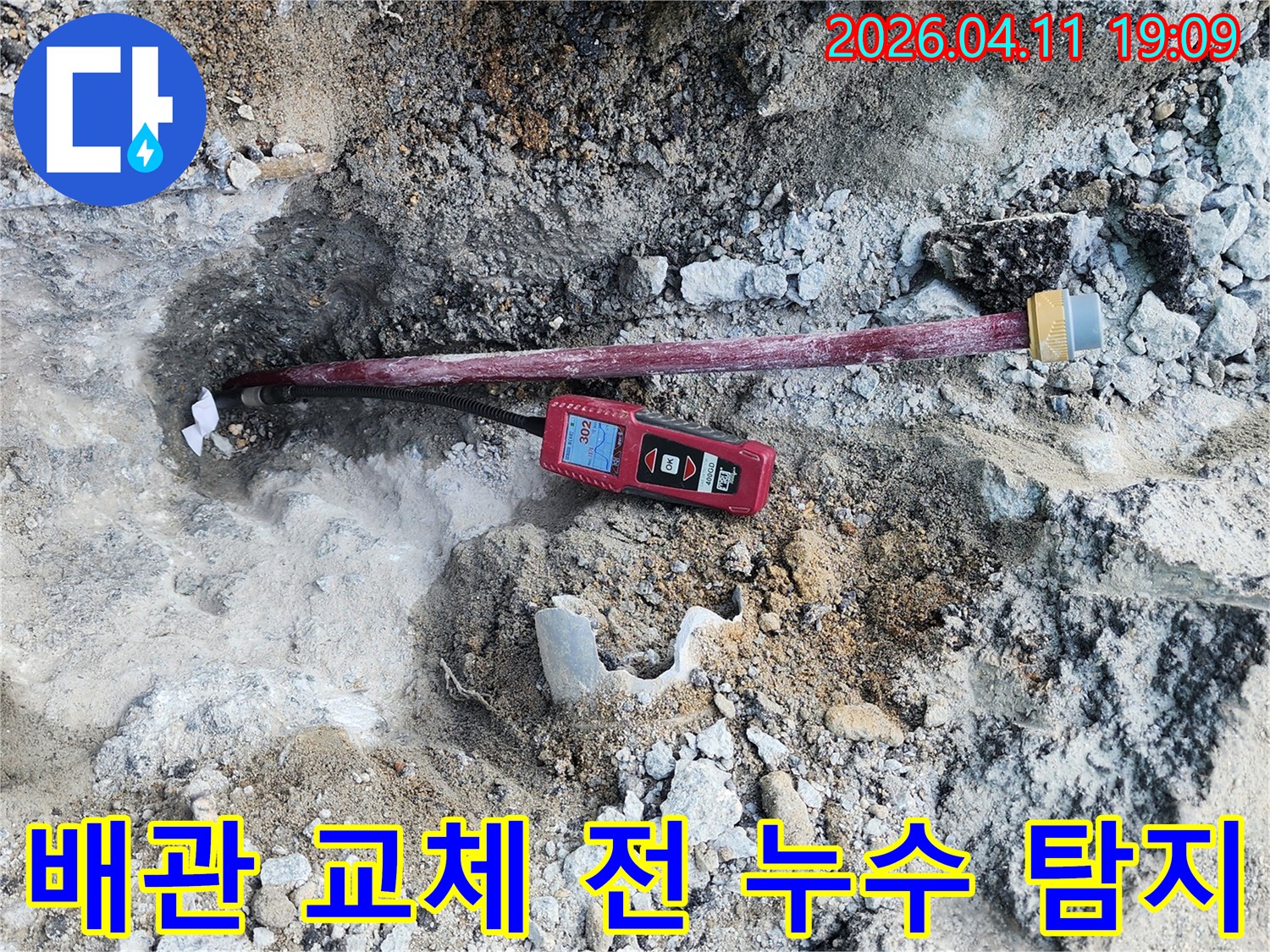 땅속에 드러난 배관과-누수 탐지 장비가-연결되어 있는-작업 현장입니다.