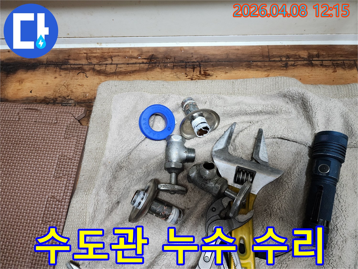 수도관 누수 수리 작업을 위해-준비된 새 부품들과-다양한 전문 공구들이-수건 위에 놓여 있습니다