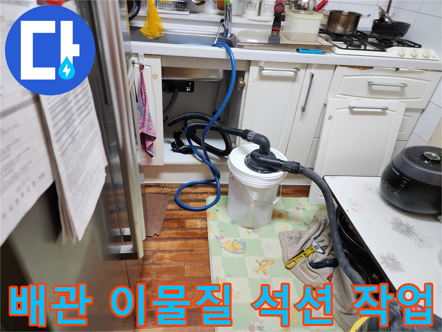 싱크대 하단 배수 라인에 석션기를 연결하여 오물을 빨아들이는 모습입니다.