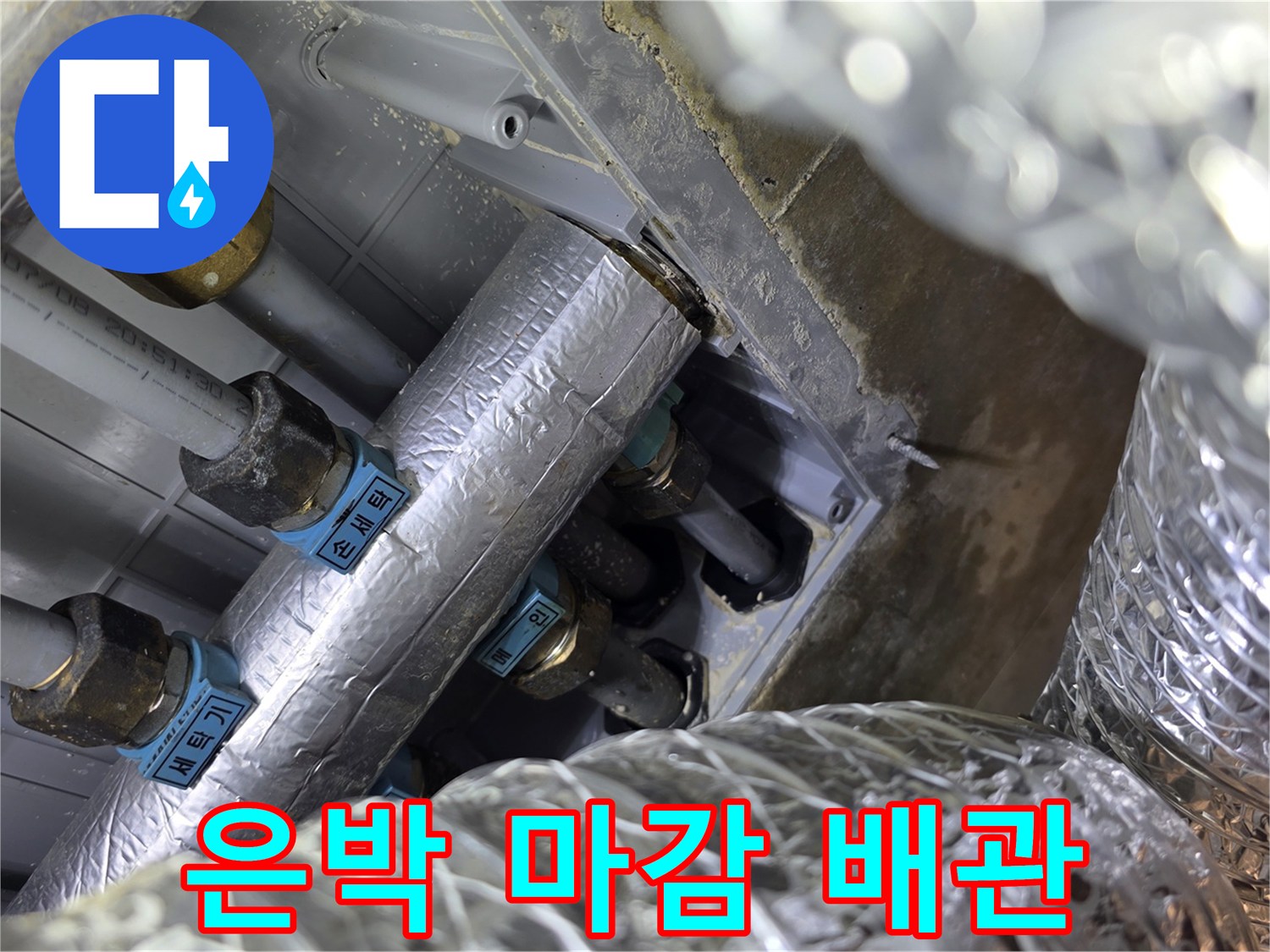천장 내부의 은박 보온재로 감싸진 수도 배관