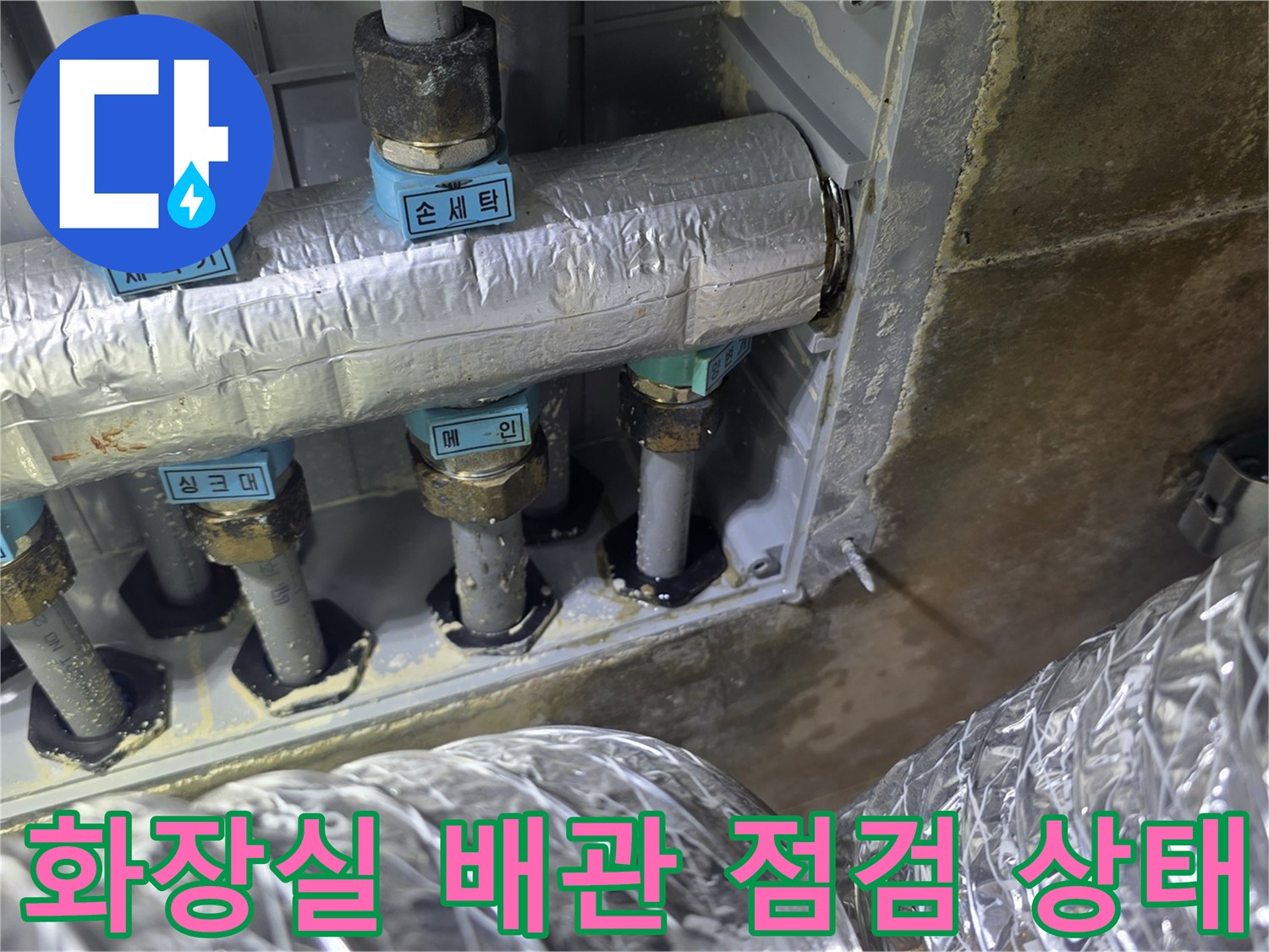 화장실 벽면 내부의 은색 보온재로 감싸진 급수 배관과 연결 부위 모습
