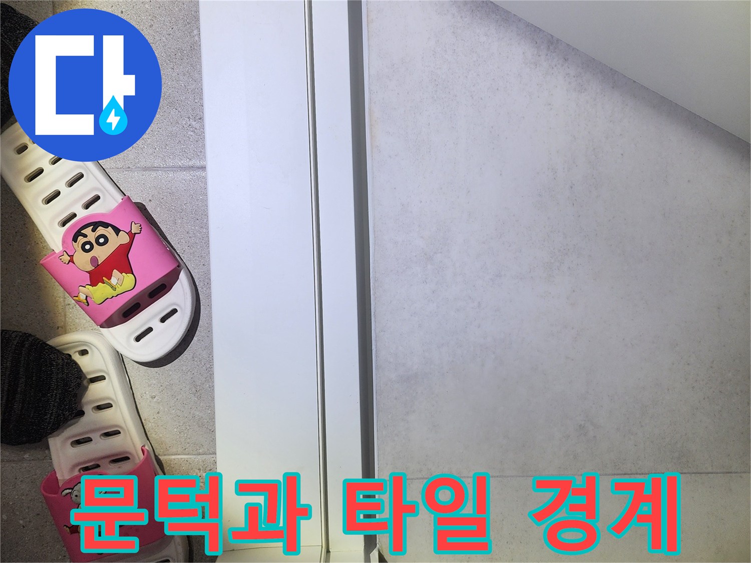 하얀색 문틀 아래쪽의 타일 마감 상태를 촬영한 사진입니다.