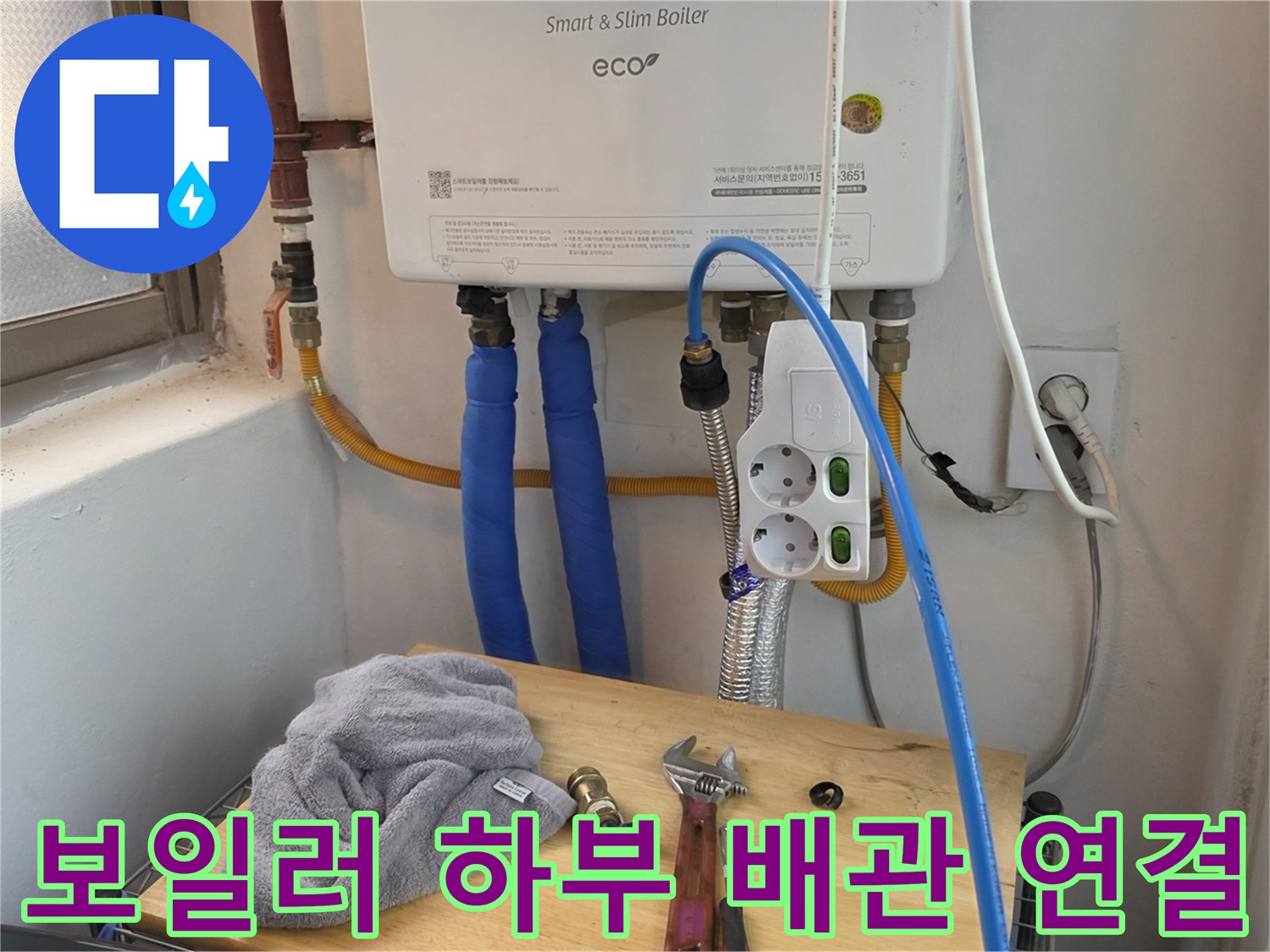 보일러와 전기 콘센트 및 파란색 온수 배관의 모습
