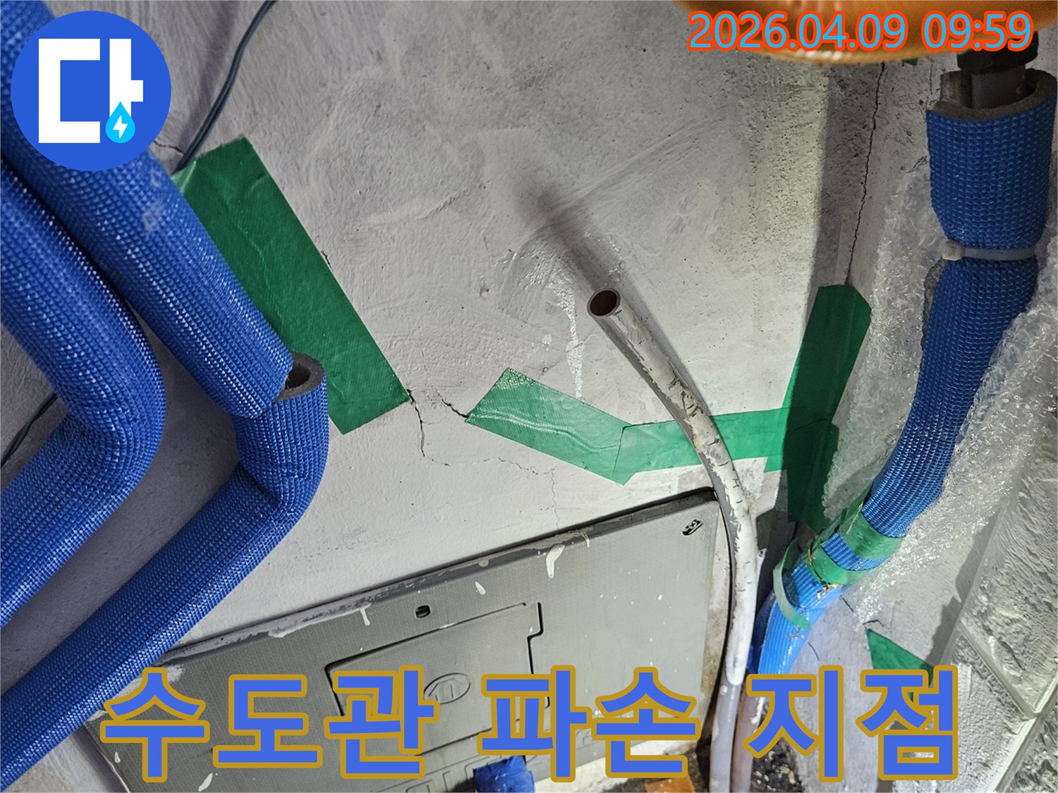 벽면 콘크리트의-균열과 함께-파란색 보온재로 감싸인-수도 배관이-노출된-누수 발생 현장-그리고 전기함 주변