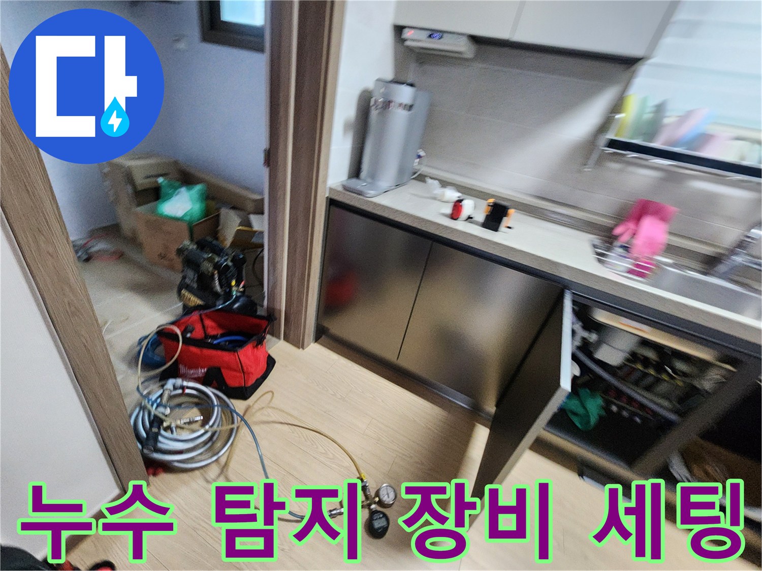 싱크대 하부 바닥에 놓인 누수 측정용 압력계와 연결된 튜브 호스