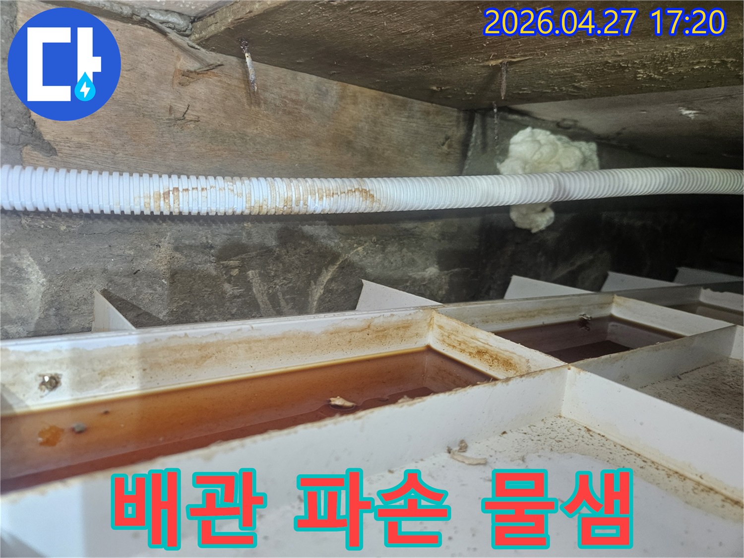 파손된 배관 주변으로-물이 새어 나오는 모습과-임시 물받이