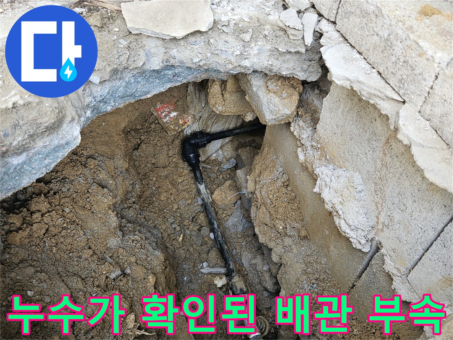 파헤쳐진 흙과 콘크리트 사이-물샘이 발견된 검은색 배관 연결부