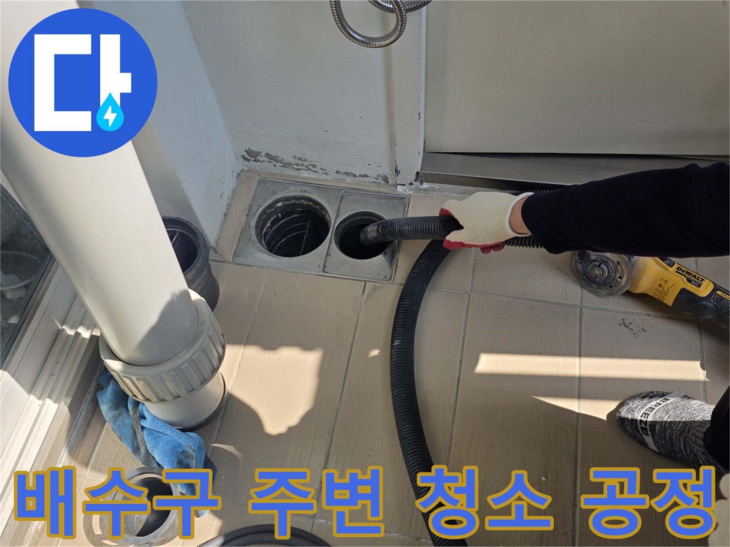 진공청소기를 이용해 배수관 틈새를 정밀하게 청소하는 모습