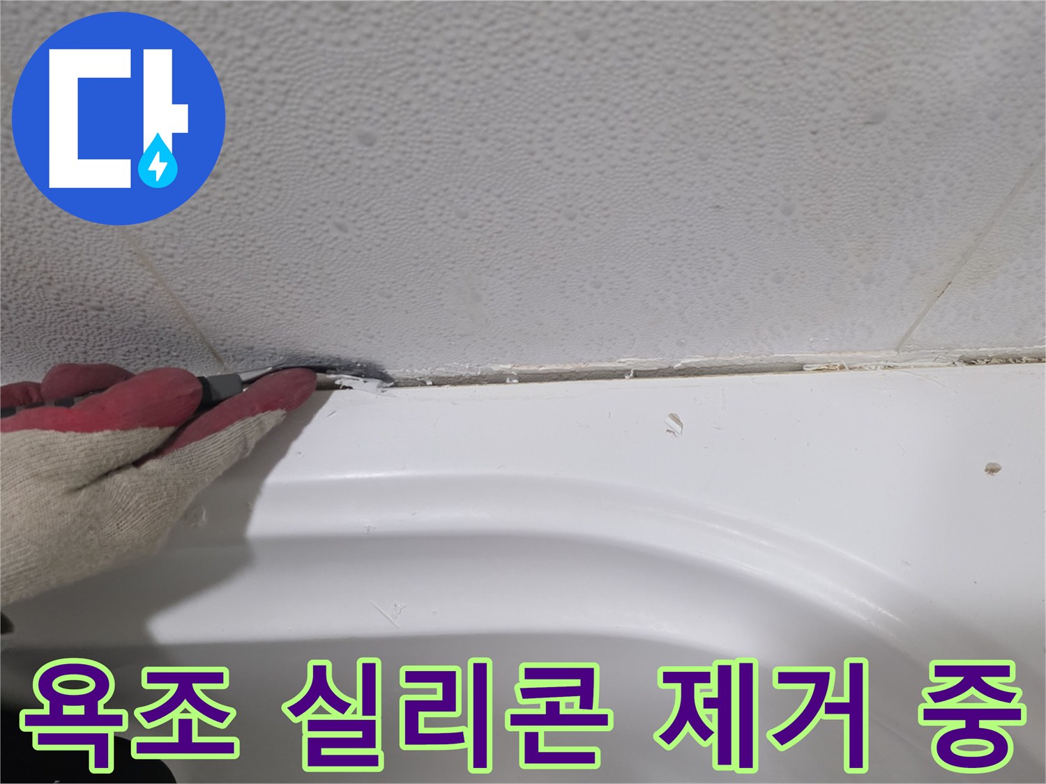 칼을 사용하여 욕조 가장자리의 낡은 마감재를 정리하는 장면