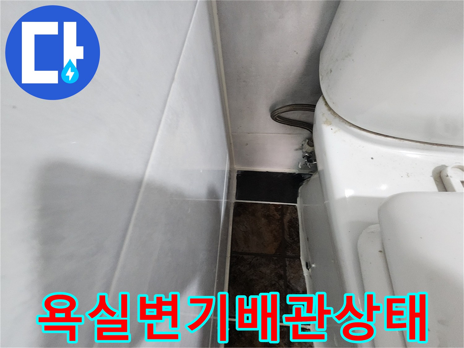 변기 뒤쪽 벽면 타일과 배관 호스 연결 부위 클로즈업