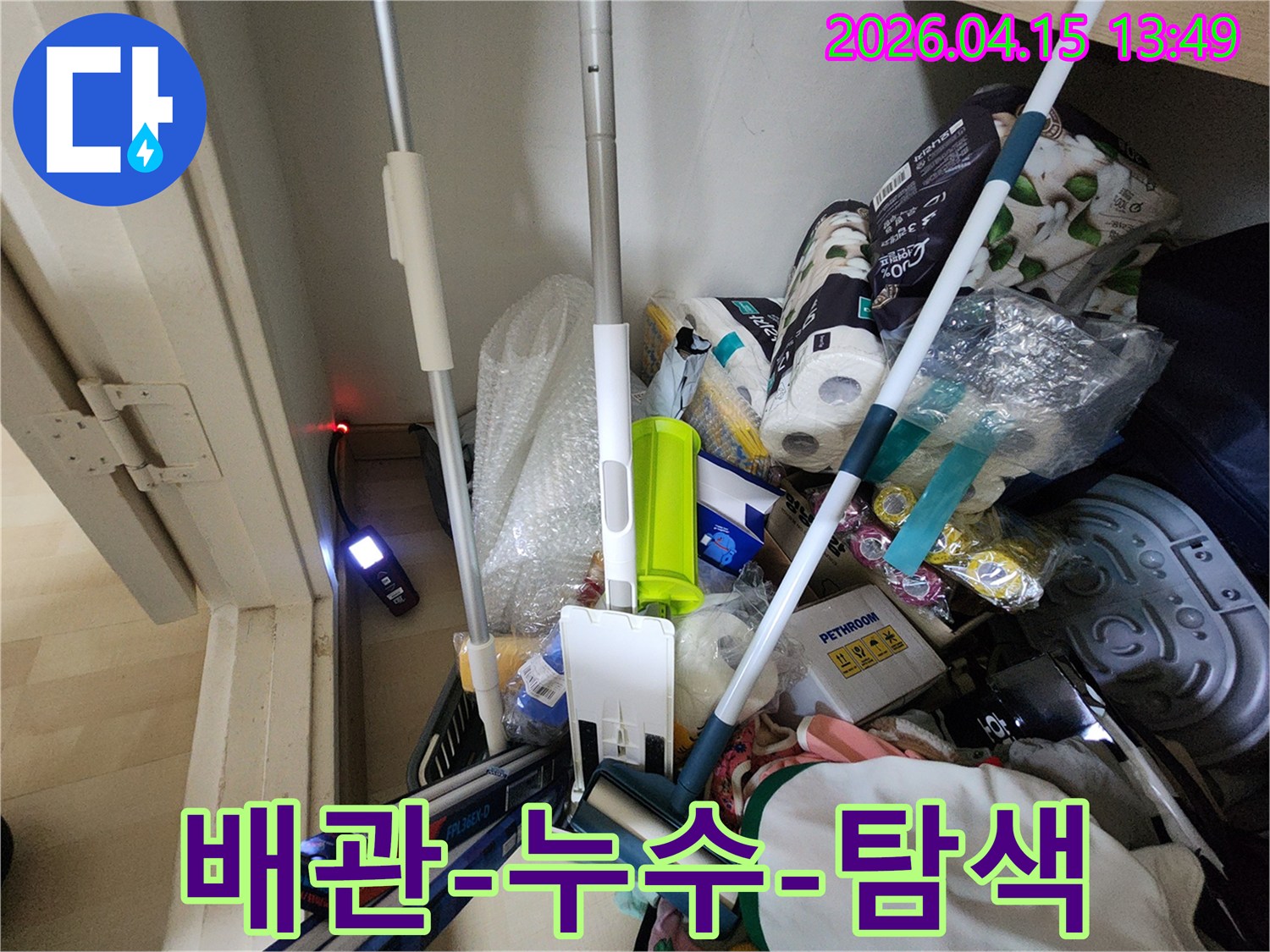 어수선한-수납공간-안에서-누수-탐지-장비가-정확한-누수-지점을-가리키고-있습니다