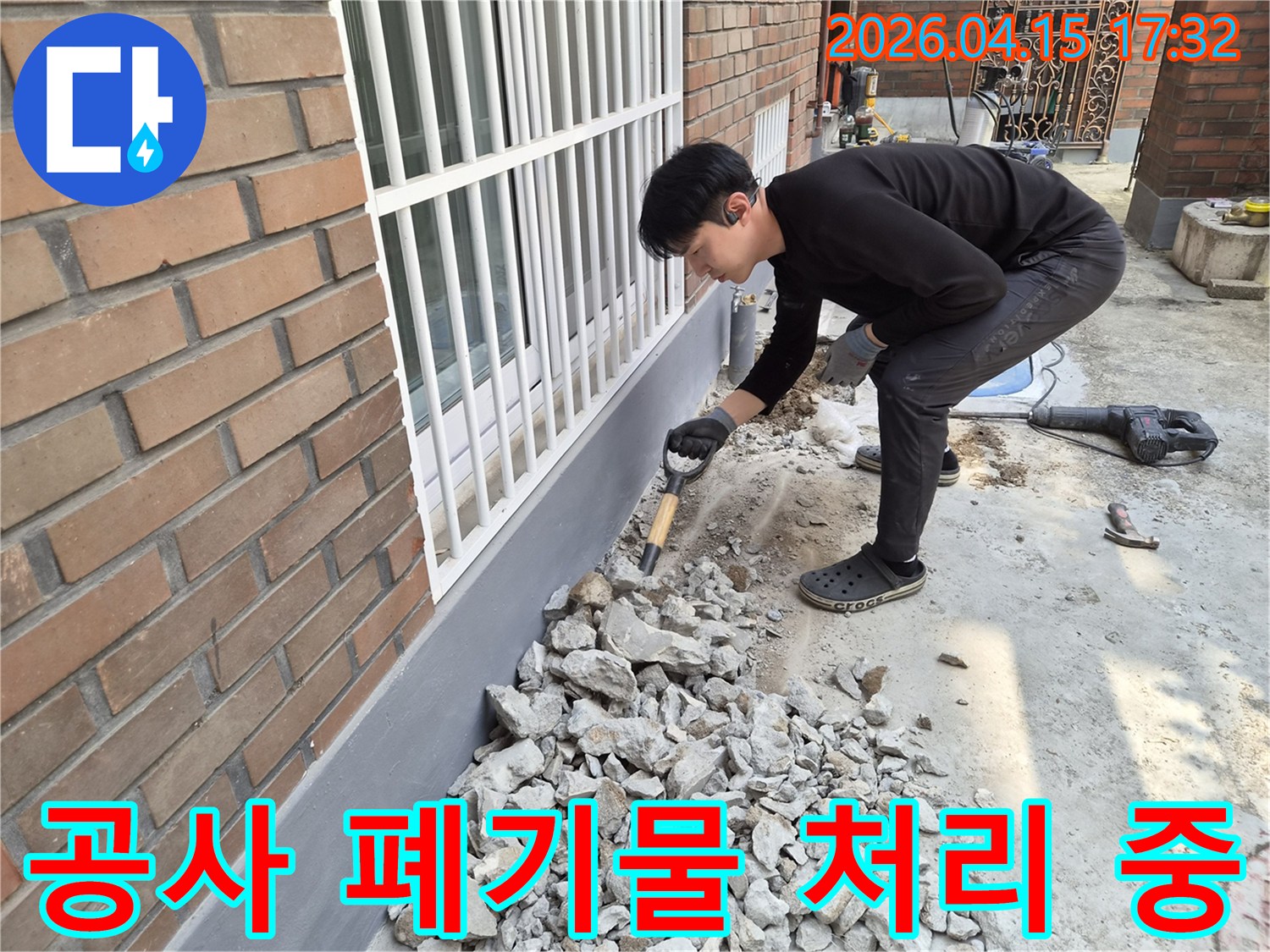 누수 공사 현장에서-작업자가 발생한 폐기물을 정리하여-안전한 작업 환경을 조성하고 있습니다