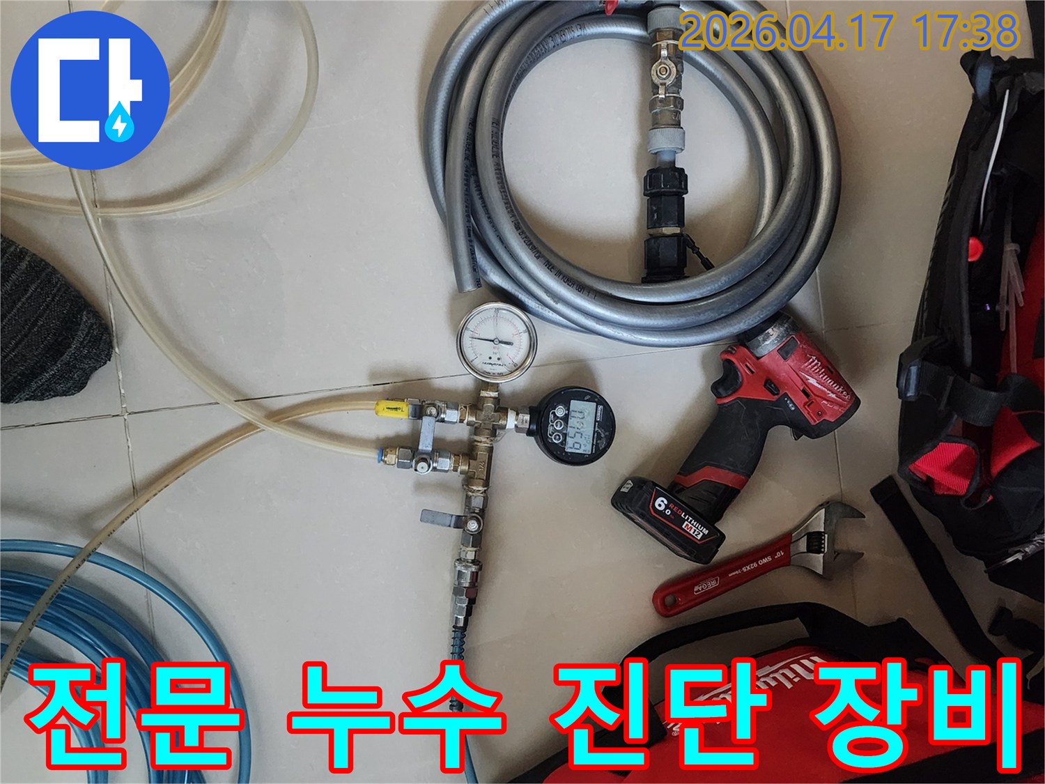 누수 탐지 작업을 위해-압력계와 연결 호스-그리고 전동 공구들이-작업 현장에 가지런히 놓여 있습니다