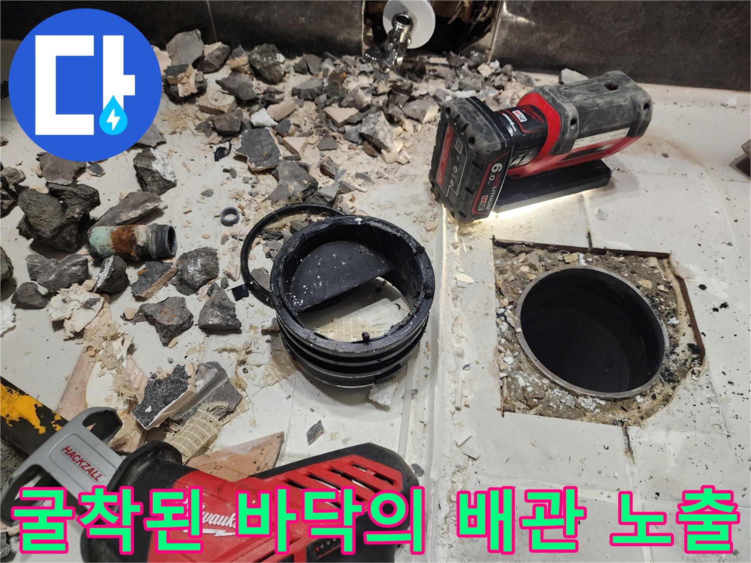 타일을 깨고 드러난 배관 부위와 작업용 전동 도구들
