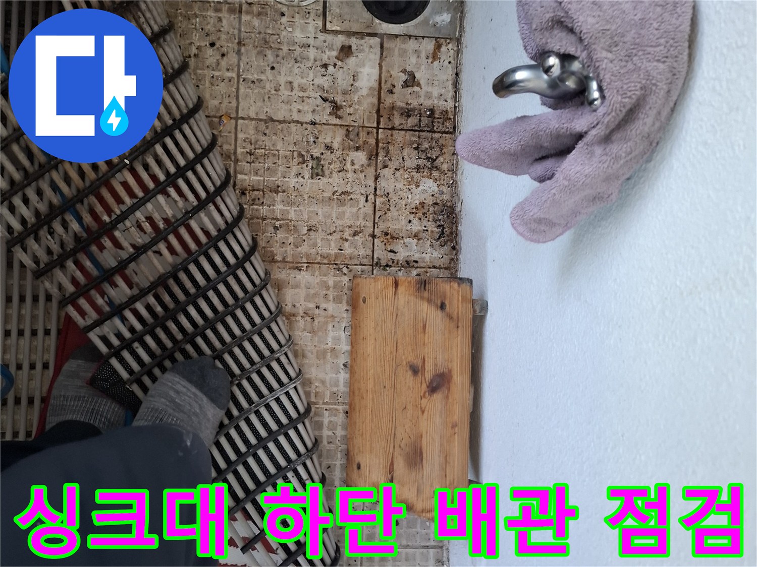 수전 배관과 바닥 배수구 주변의 타일 상태를 촬영한 모습