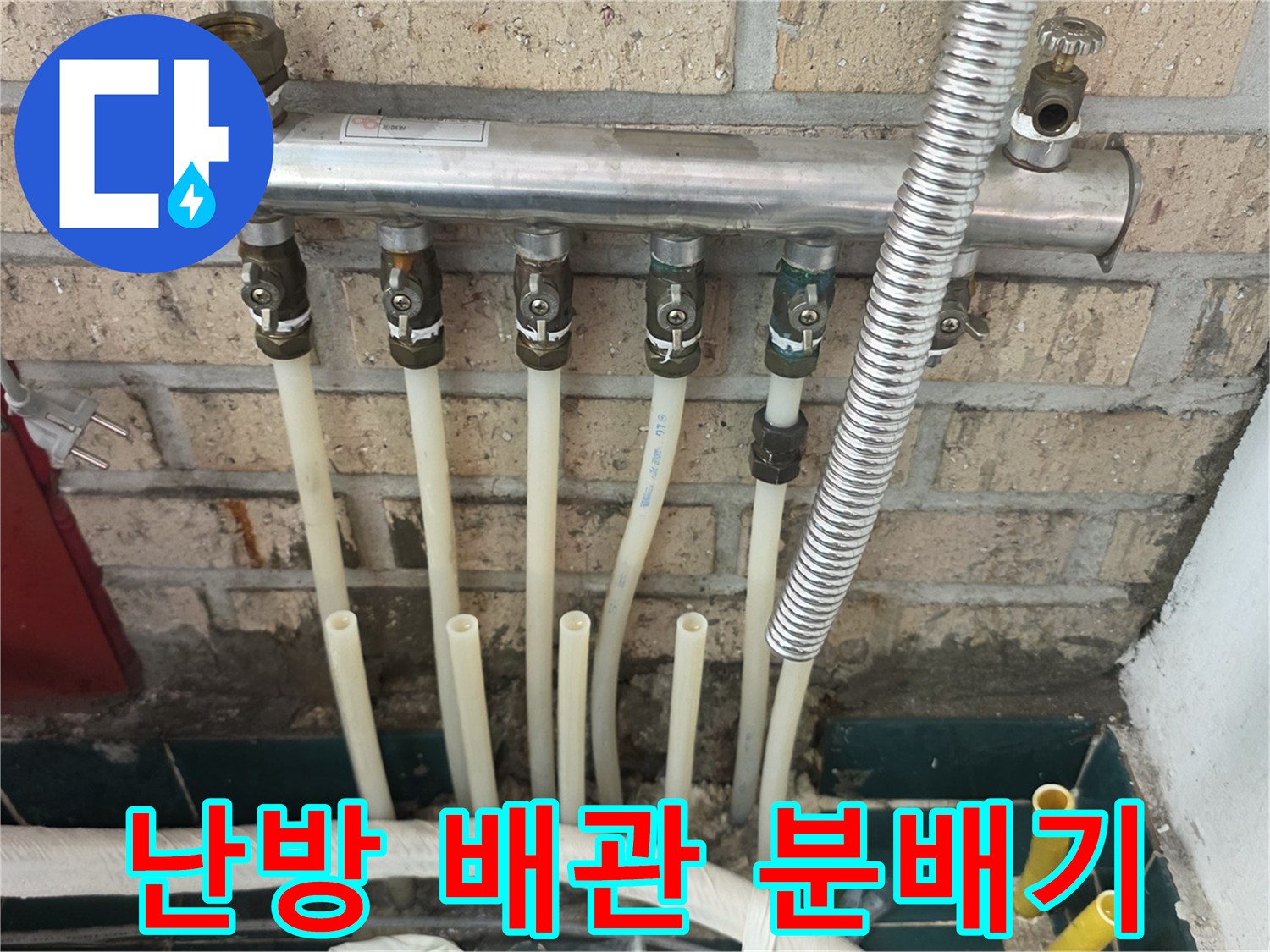 벽돌 벽면에 설치된 금속제 분배기와 연결 배관입니다.
