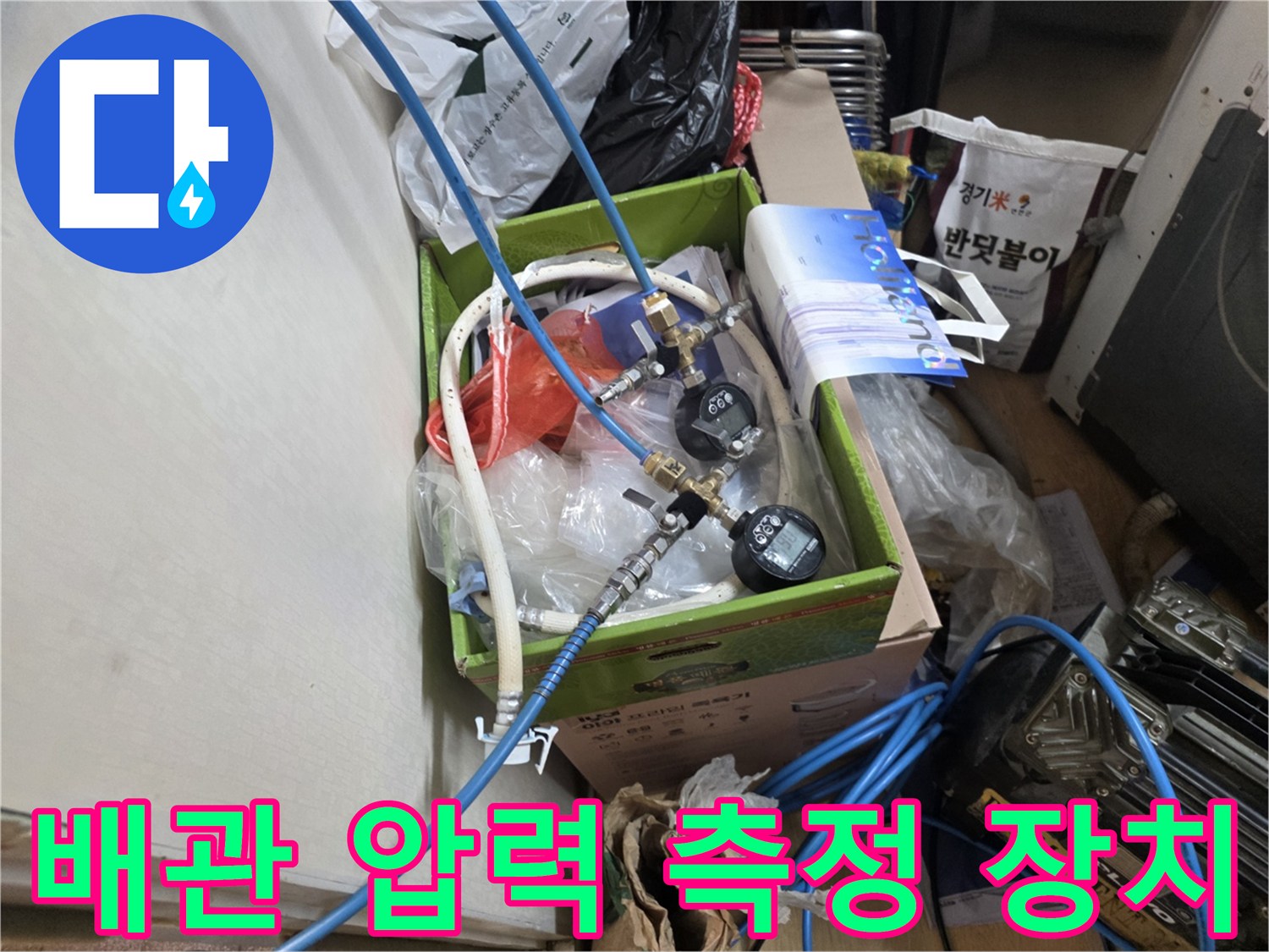 누수 부위 확인을 위해 배관에 연결된 파란색 호스와 압력 게이지