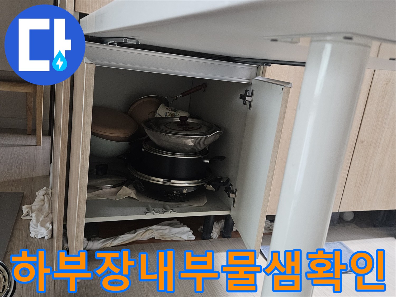 싱크대 수납장 안쪽의 식기류와 누수 점검을 위한 내부 상태