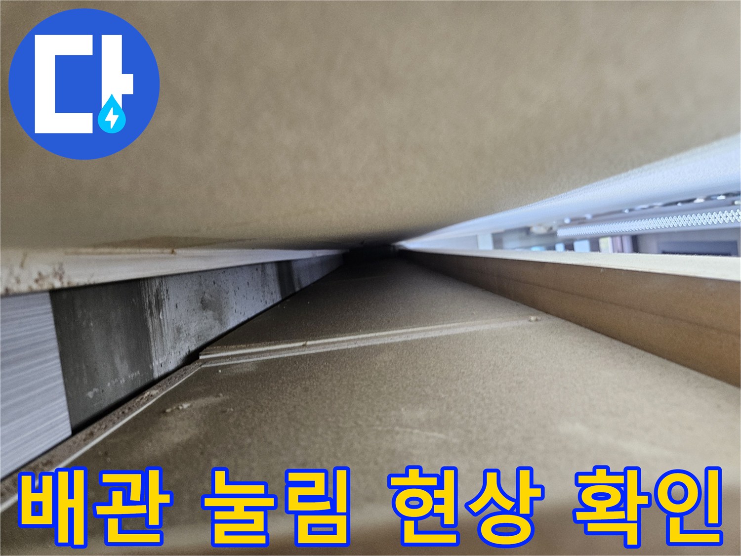 싱크대 하단 배관의 찌그러진 부위를 클로즈업한 사진입니다.
