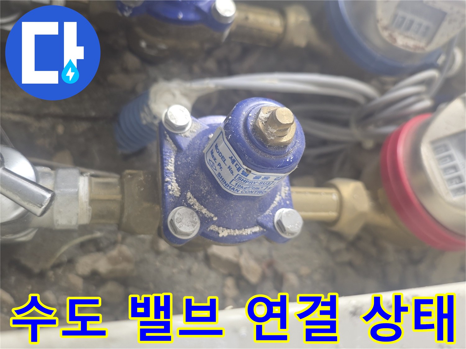 계량기 주변의 수도 밸브와 금속 배관이 연결된 모습입니다.