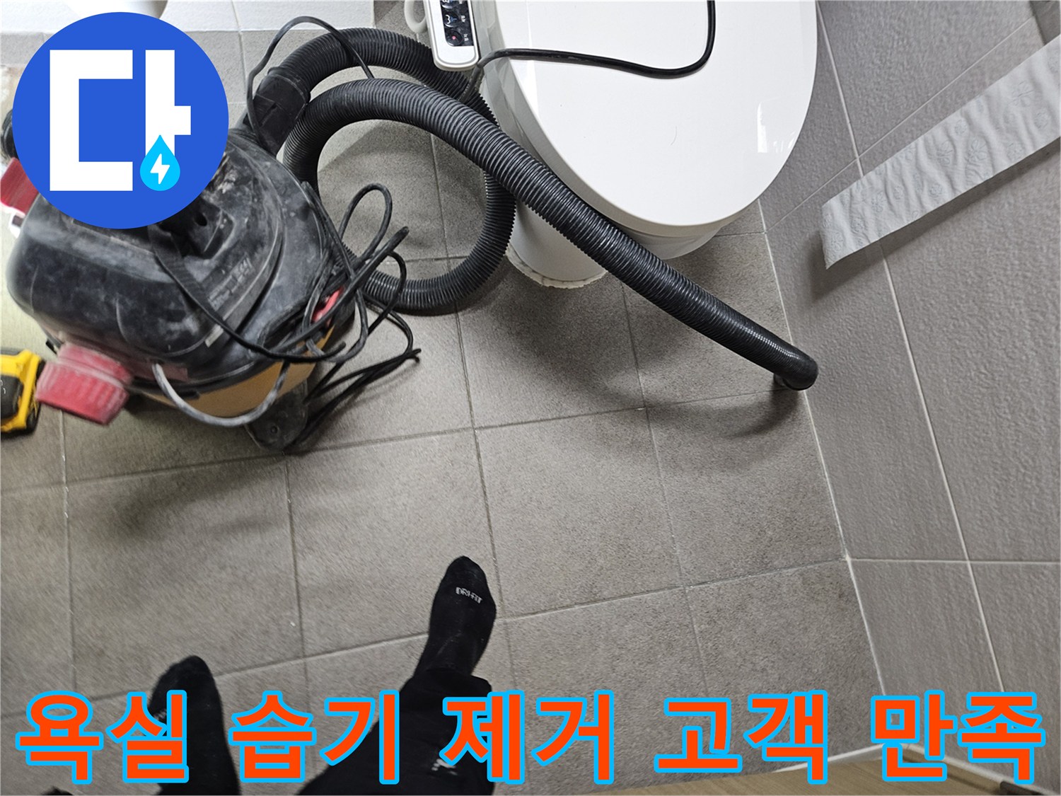 오산시 고객 댁 욕실에서-누수 엔지니어가-변기 주변의 습기를-습식 청소기로 제거하며-고객 만족을 위해 최선을 다하는 모습