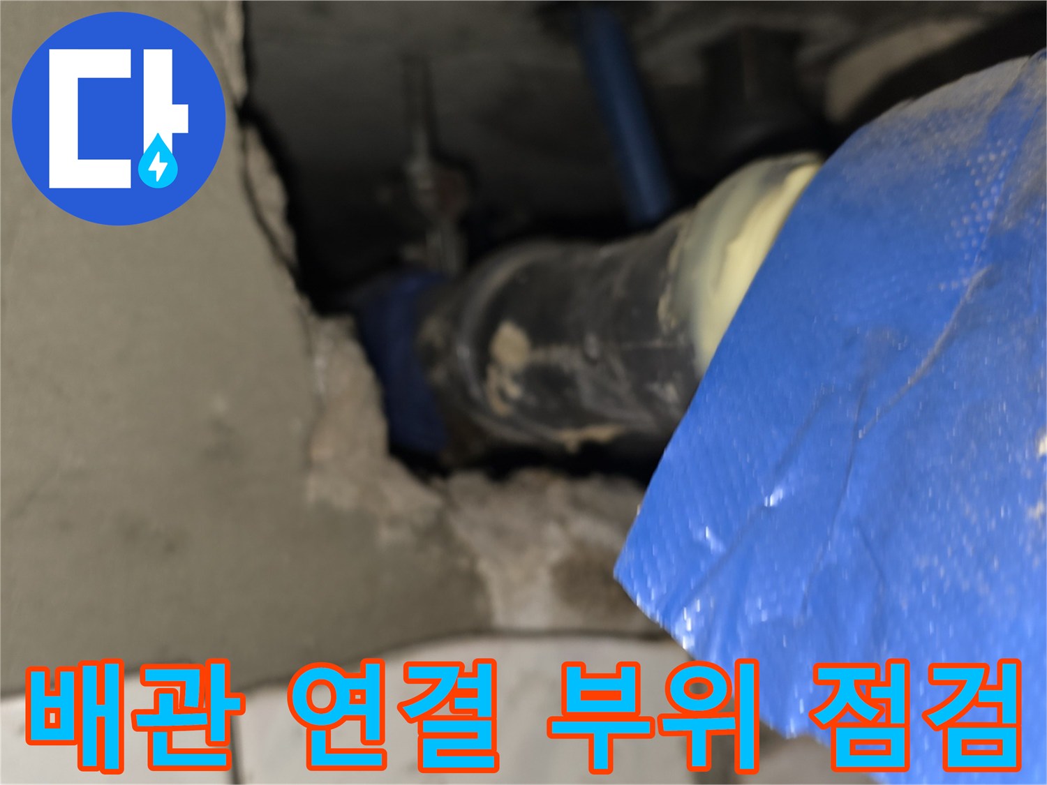 파란색 보온재로 감싸진 배관의 연결 부위 결함을 확인하는 모습