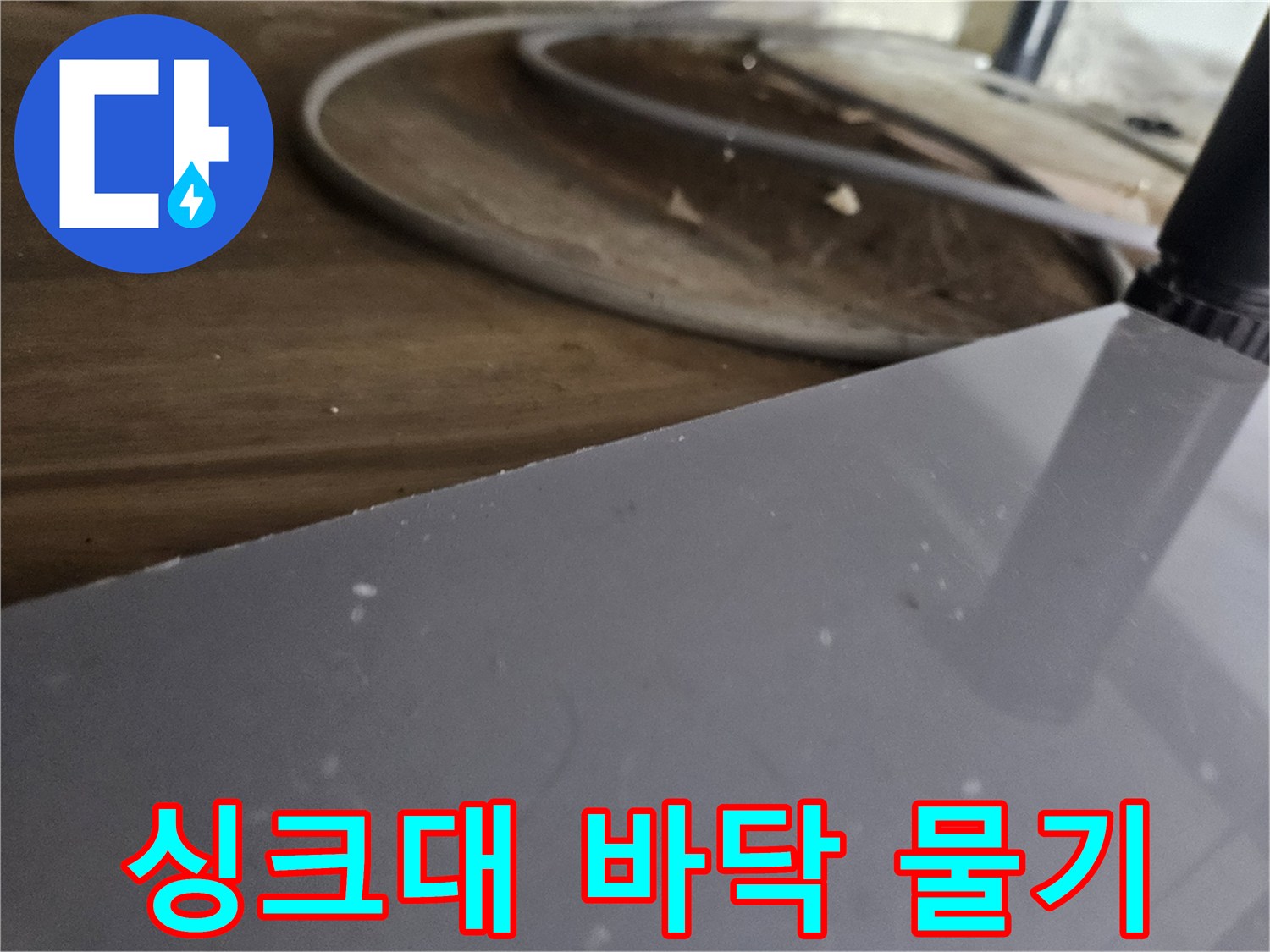 싱크대-아래-목재-선반에-맺힌-물기를-통해-누수-진행-상황을-파악하는-모습
