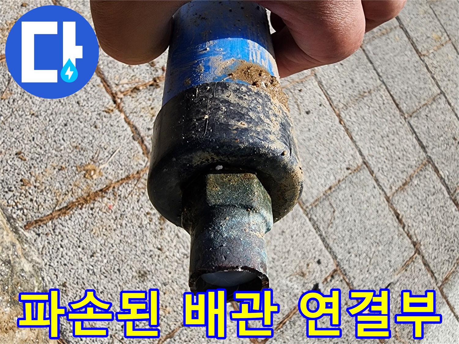 흙 묻은 검은색 커넥터와 파란색 관의 파손 부위