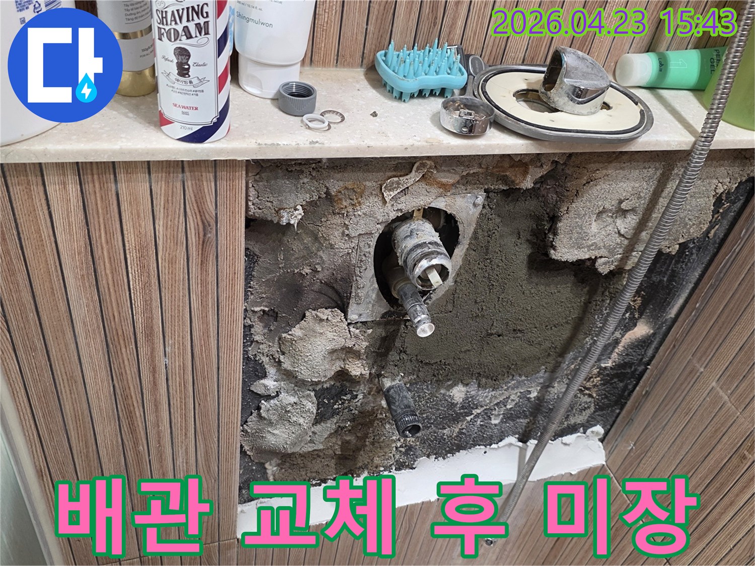 욕실 벽면의 오래된 배관에서 발생한 누수를 수리하기 위해-타일을 철거하고-새 배관으로 교체한 후-미장 작업을 준비하는 모습입니다