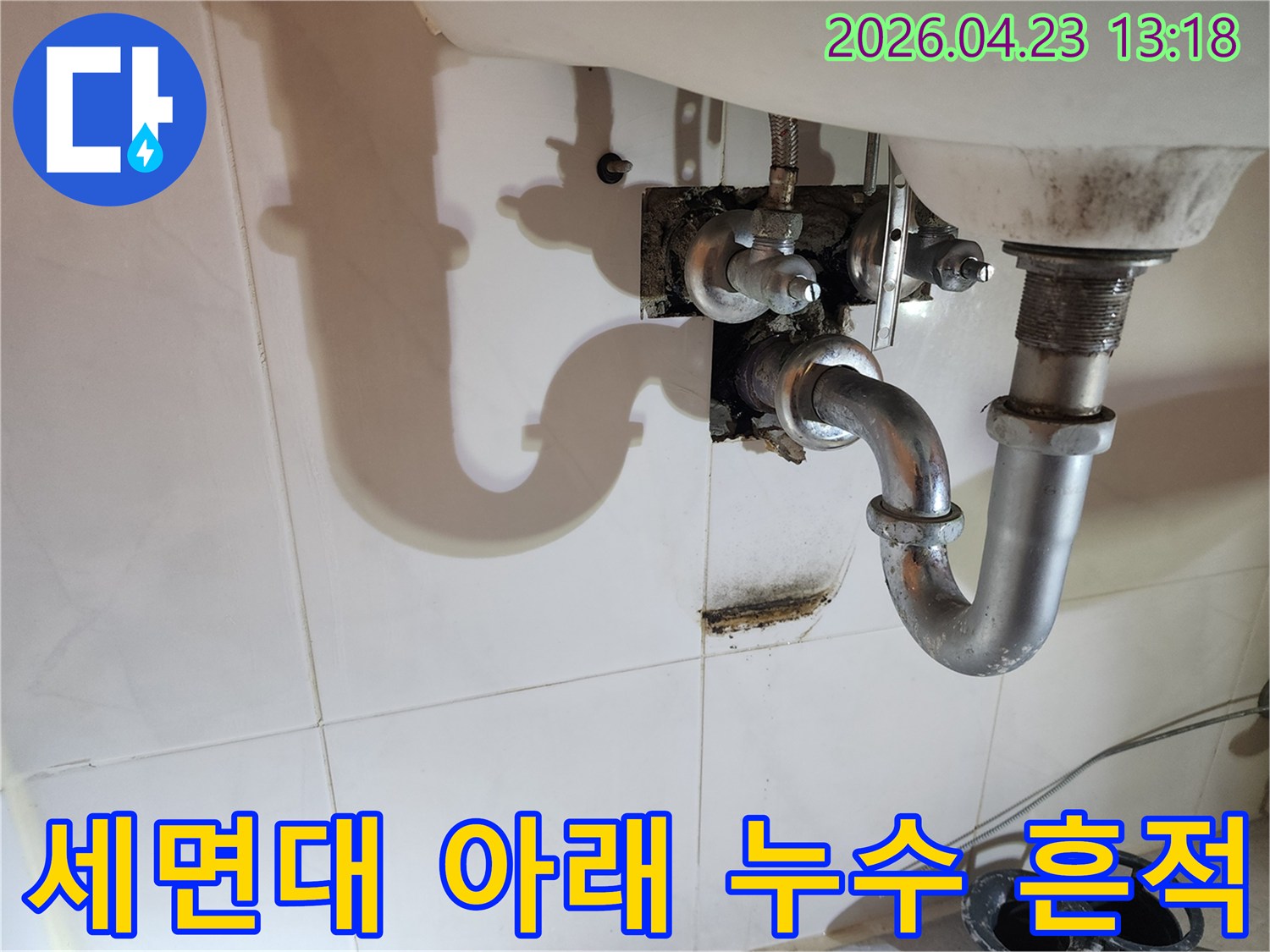 양주자이4단지 아파트 화장실 세면대 아래 배관에서 발생한-오랜 기간 지속된 누수로 인한 벽면 오염을 보여주는 사진입니다.