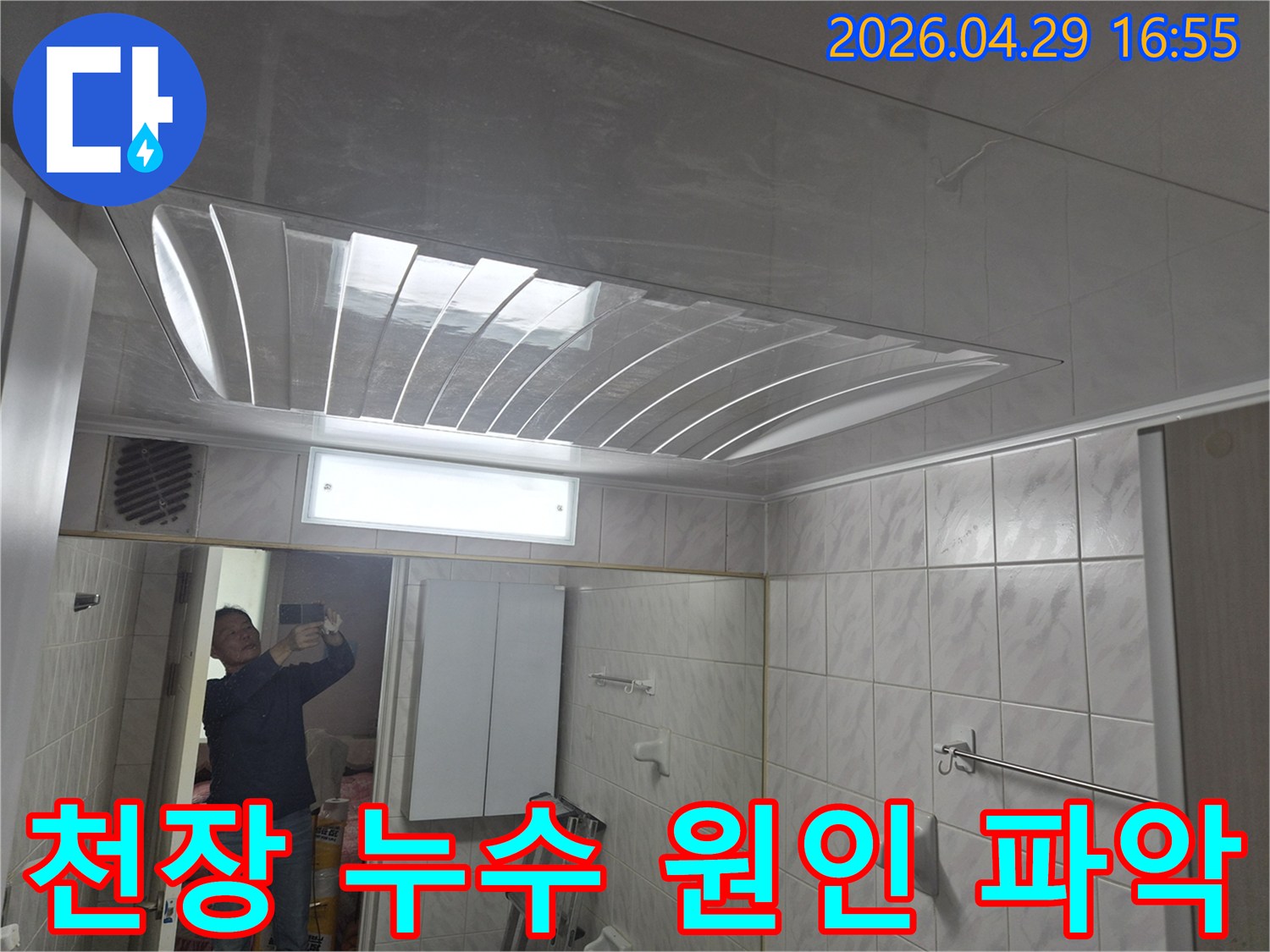 욕실-천장의-돔-형태-마감재와-조명-그리고-거울에-반사된-엔지니어의-모습이-담긴-누수-현장-점검-사진