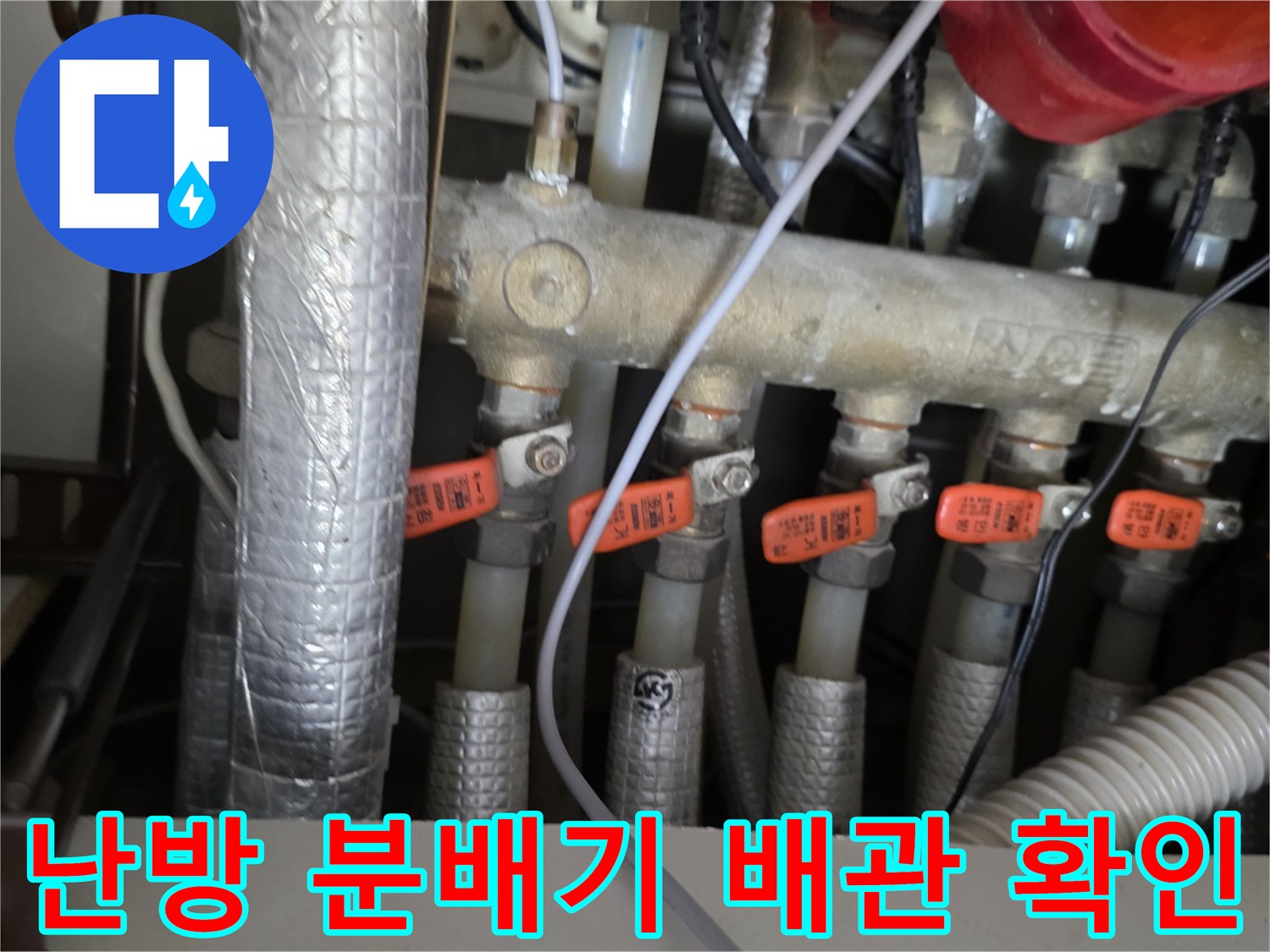 싱크대 아래 설치된 난방 분배기 및 연결 배관 사진