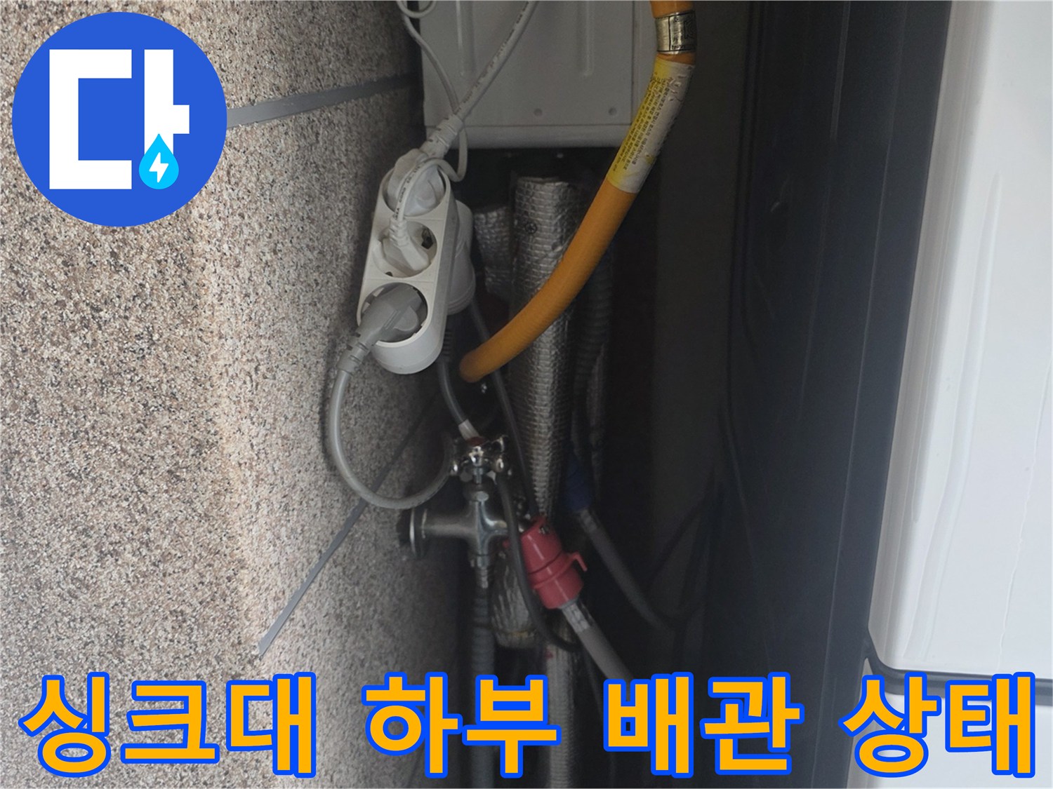 주방 싱크대 하부장의 배수 호스와 연결 부속 모습