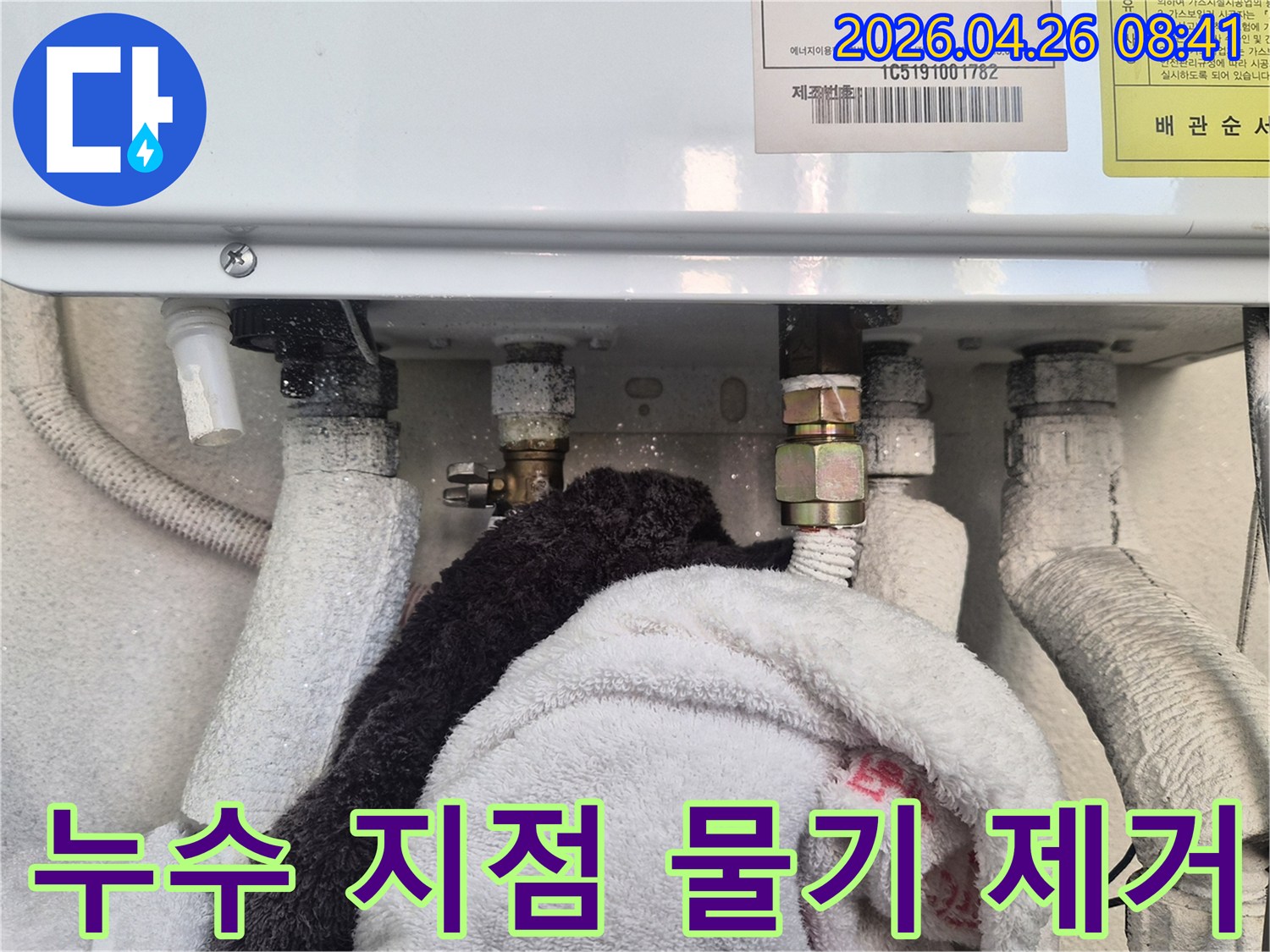 보일러 배관 누수 지점에서 물기를 흡수하기 위해 수건을 사용하고 있는 모습