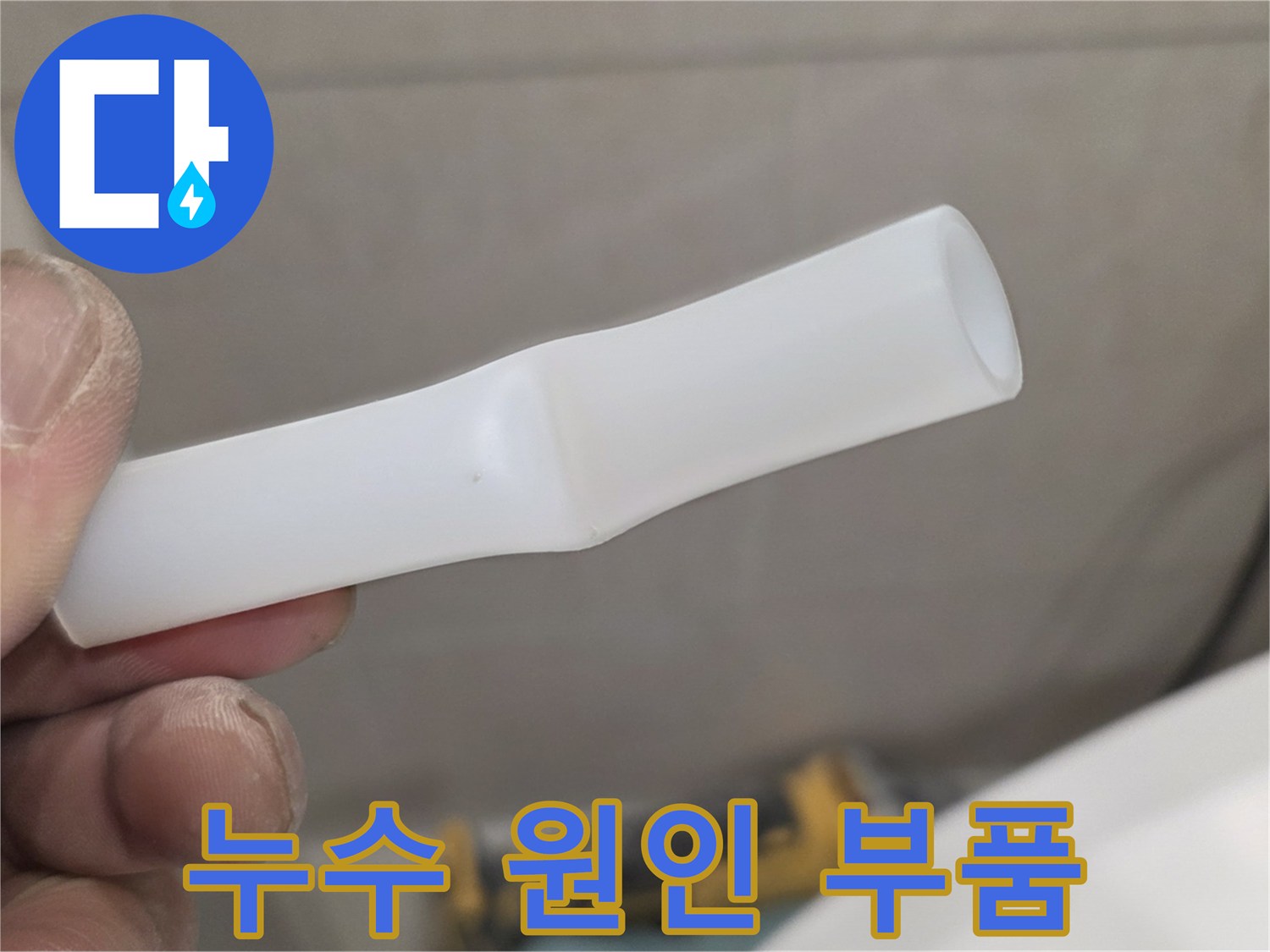 손에 쥐고 있는 파손된 배관 연결용 플라스틱 소품